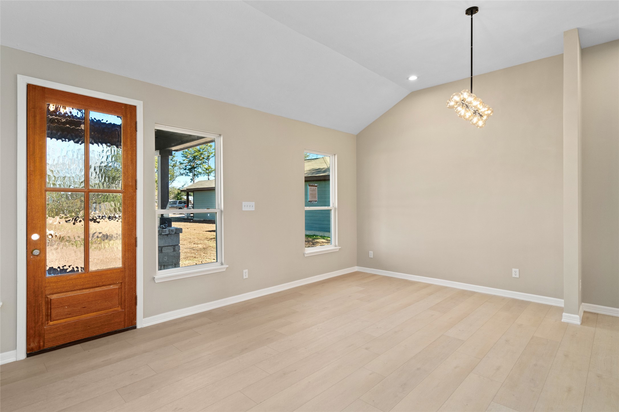 Bright and welcoming entry
view featuring a rich wood
front door with glass panels.
Natural light streams through
side windows, highlighting
the airy, modern living room.