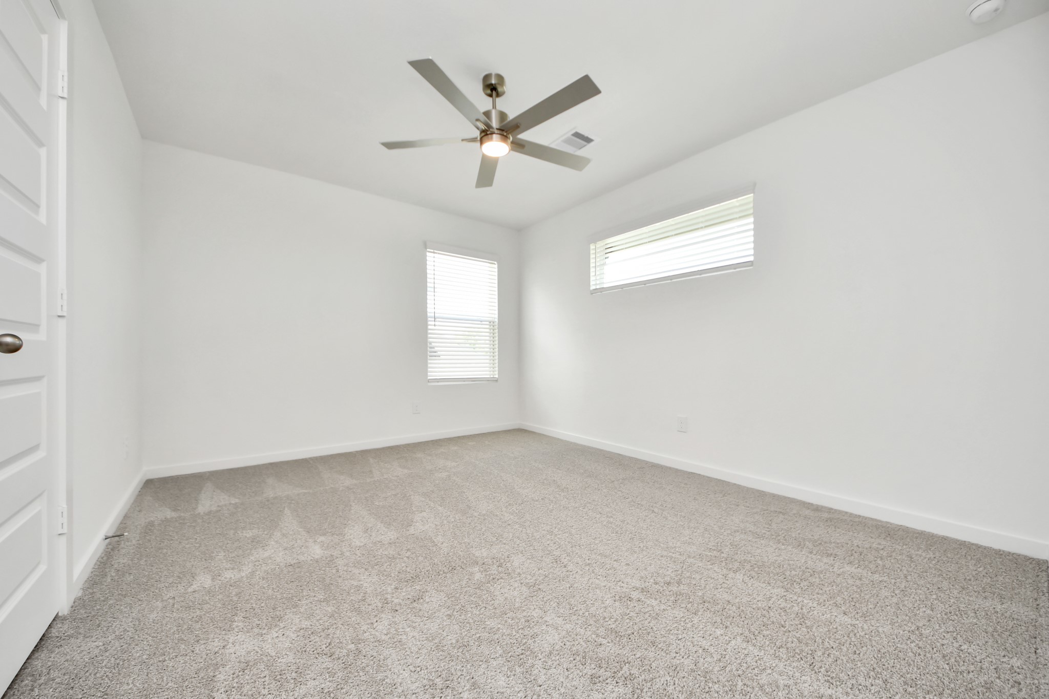 Secondary bedroom features plush carpeting, large windows that let in plenty of natural light, bright paint, and spacious closets. Sample photo of completed home with similar floor plan. Actual colors and selections may vary.