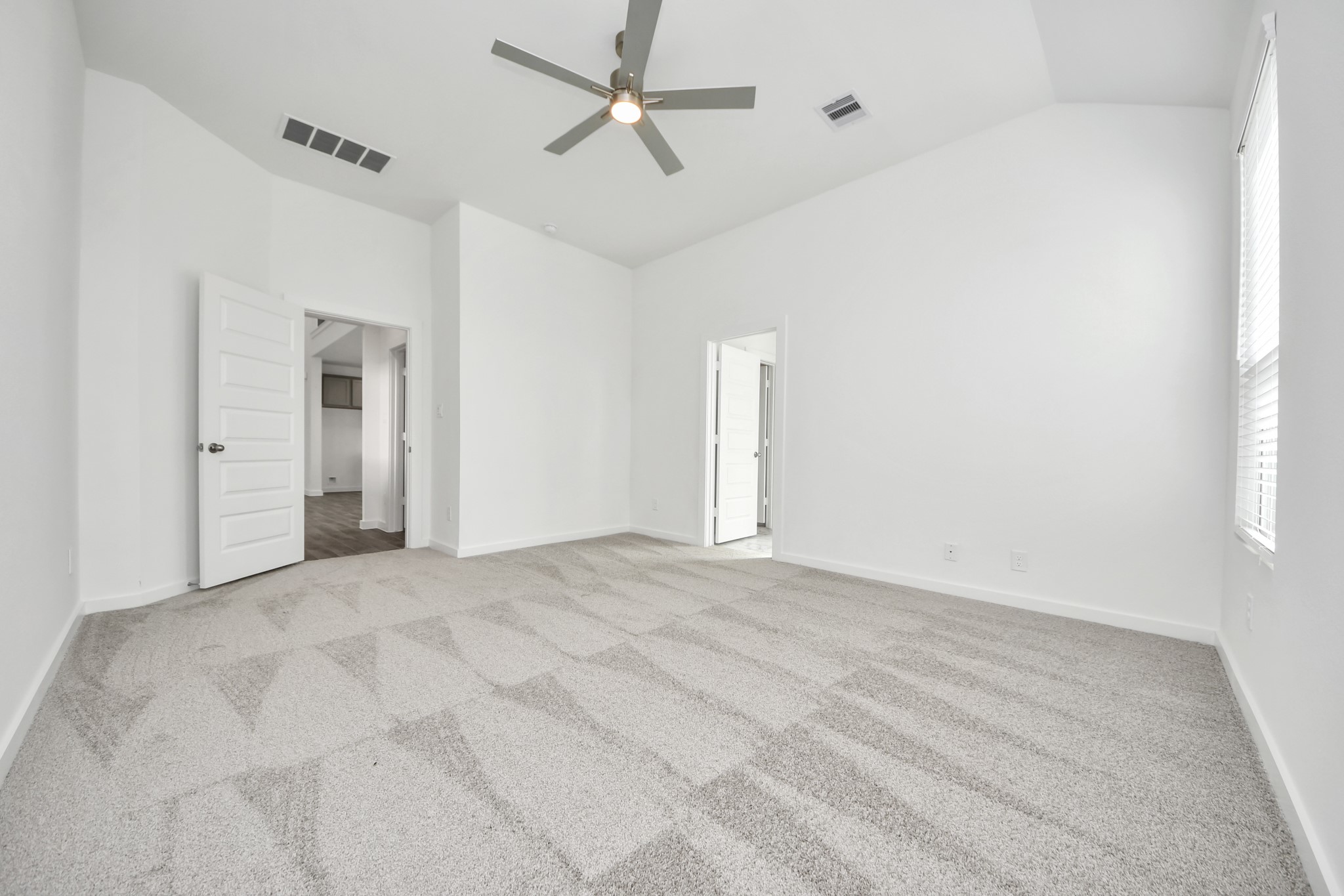 Come and unwind after a long day in this magnificent primary suite! This spacious room features plush carpet, warm paint, high ceilings and large windows with privacy blinds. Sample photo of completed home with similar floor plan. Actual colors and selections may vary.