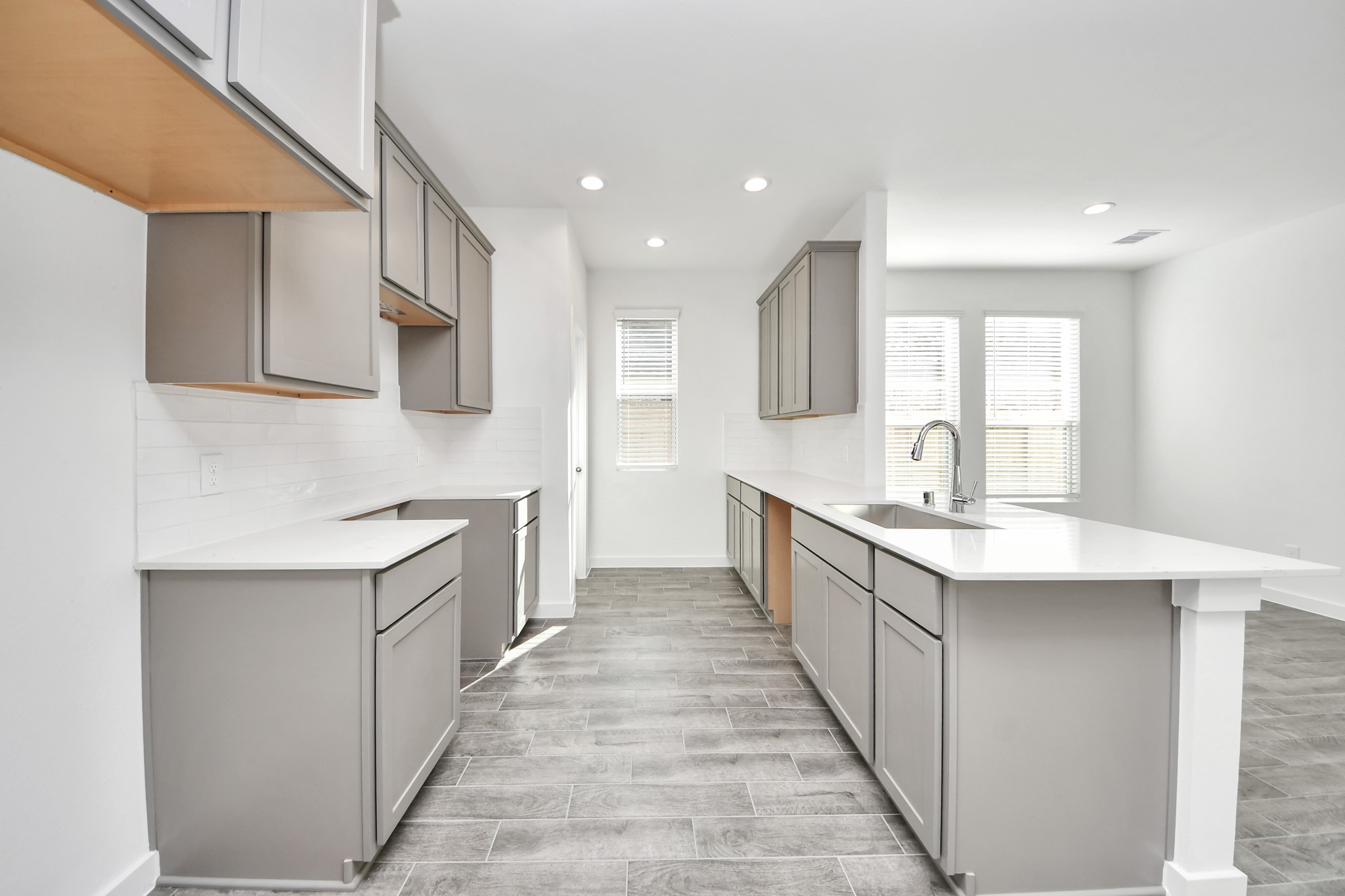 Culinary haven, featuring granite countertops, a tile backsplash, stainless steel appliances (to be installed), and 42 upper cabinets. Sample photo of completed home with similar floor plan. Actual colors and selections may vary. Culinary haven, featuring granite countertops, a tile backsplash, stainless steel appliances (to be installed), and 42 upper cabinets. Sample photo of completed home with similar floor plan. Actual colors and selections may vary.