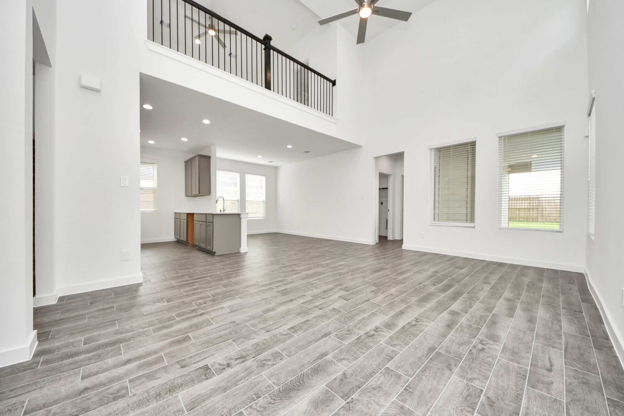 Welcome family and guests to your charming living room! With its high ceilings, recessed lighting, ceiling fan, custom paint, beautiful flooring, and large windows that let in abundant natural light, this room is perfect for gatherings. Sample photo of completed home with similar floor plan. Actual colors and selections may vary. Welcome family and guests to your charming living room! With its high ceilings, recessed lighting, ceiling fan, custom paint, beautiful flooring, and large windows that let in abundant natural light, this room is perfect for gatherings. Sample photo of completed home with similar floor plan. Actual colors and selections may vary.