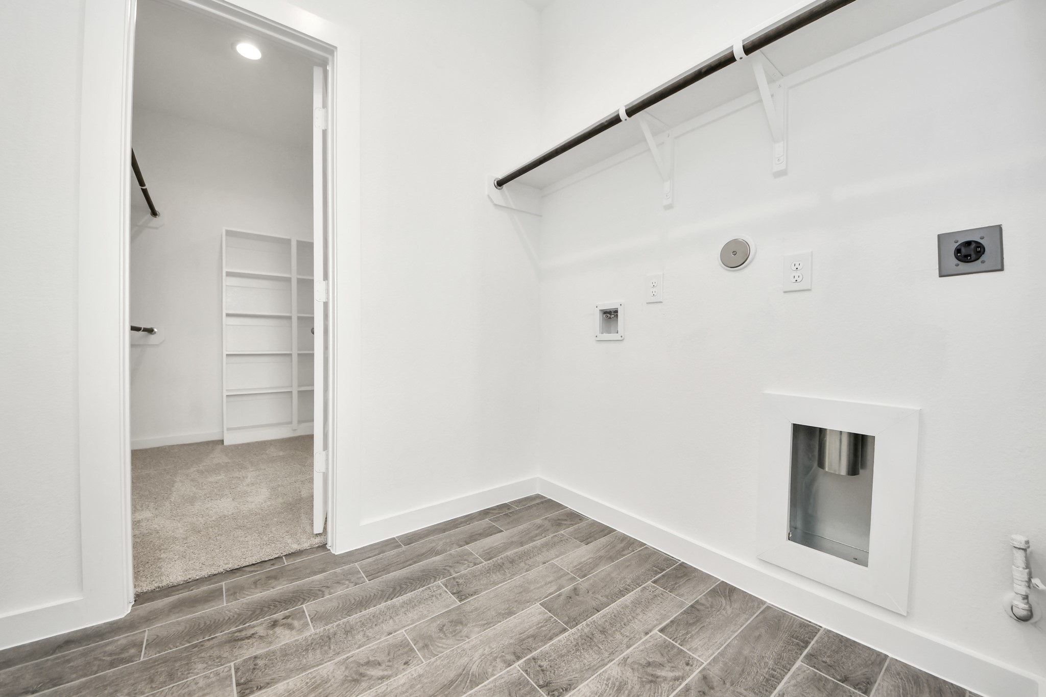 A perfect blend of functionality and comfort. Capture the essence of easy living with a first-floor laundry room, thoughtfully equipped with shelving for effortless organization. Both electric and gas connections available. Sample photo of completed home with similar floor plan. Actual colors and selections may vary.