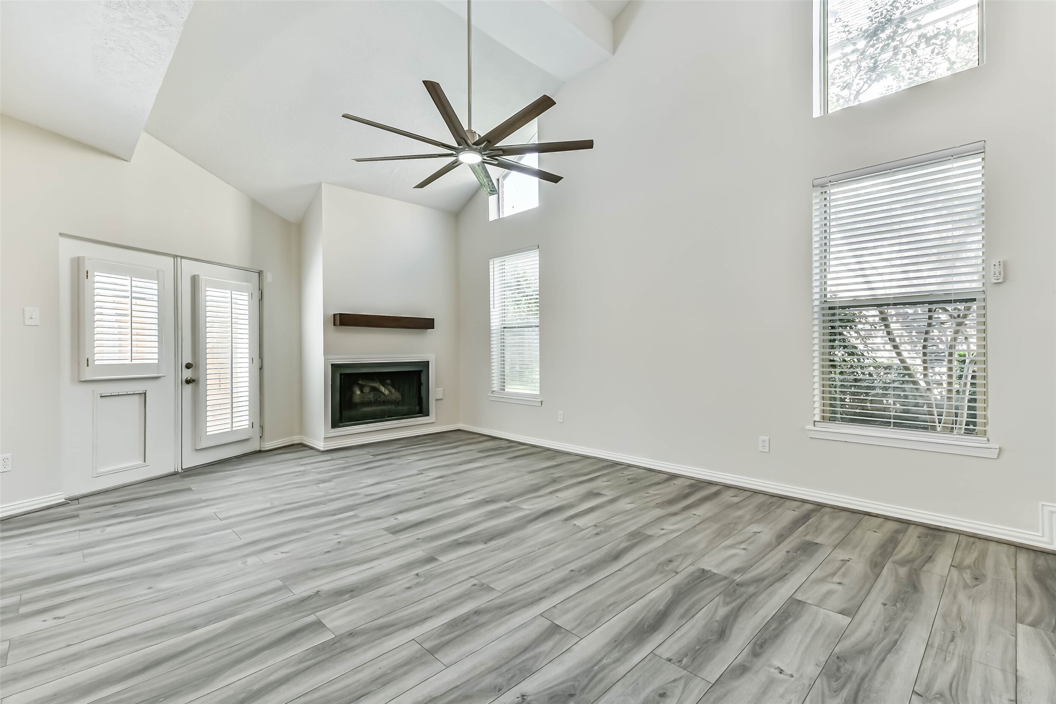 The family room has a gas fireplace and high ceilings with an over sized ceiling fan. The family room has a gas fireplace and high ceilings with an over sized ceiling fan.