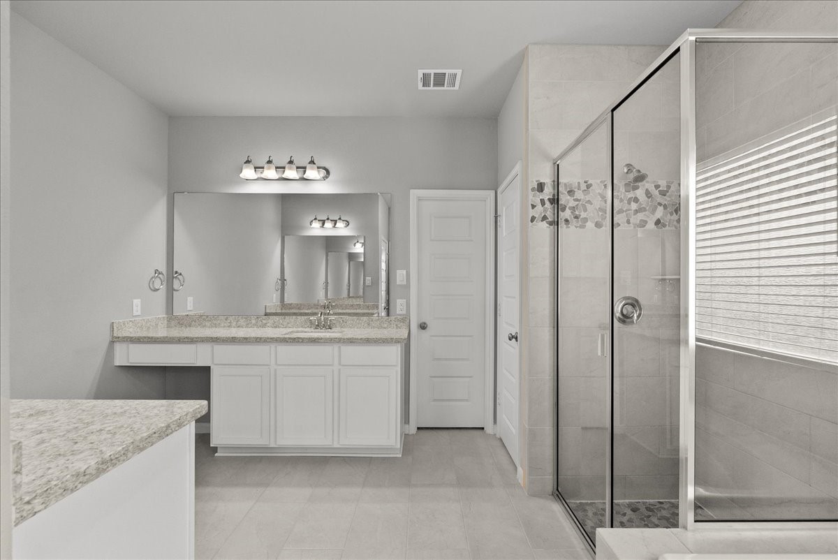 Primary bath features dual vanities, walk-in shower, soaking tub and a walk-in closet