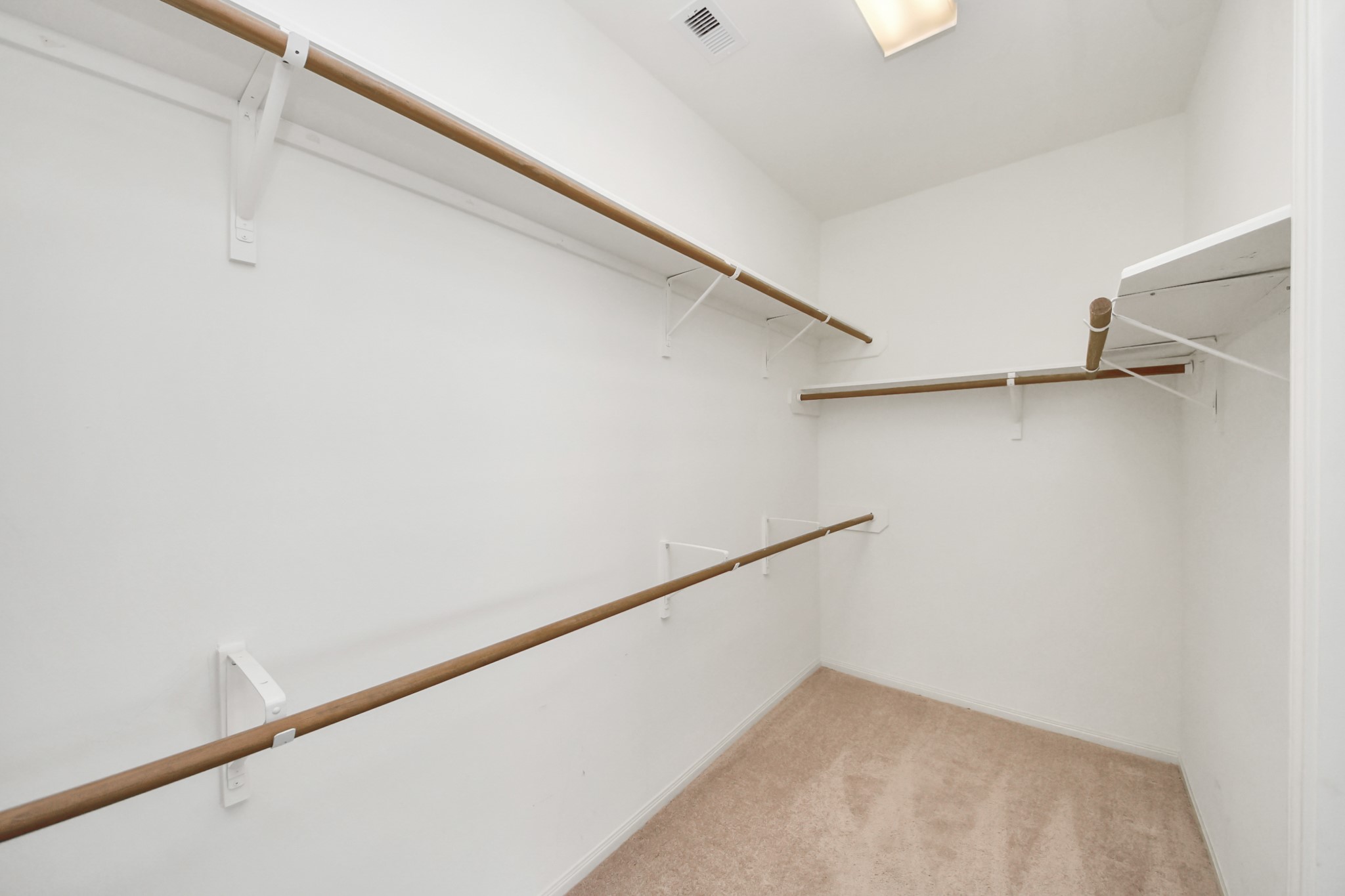 Spacious walk-in closet featuring ample hanging space and shelving, perfect for organizing your wardrobe essentials.