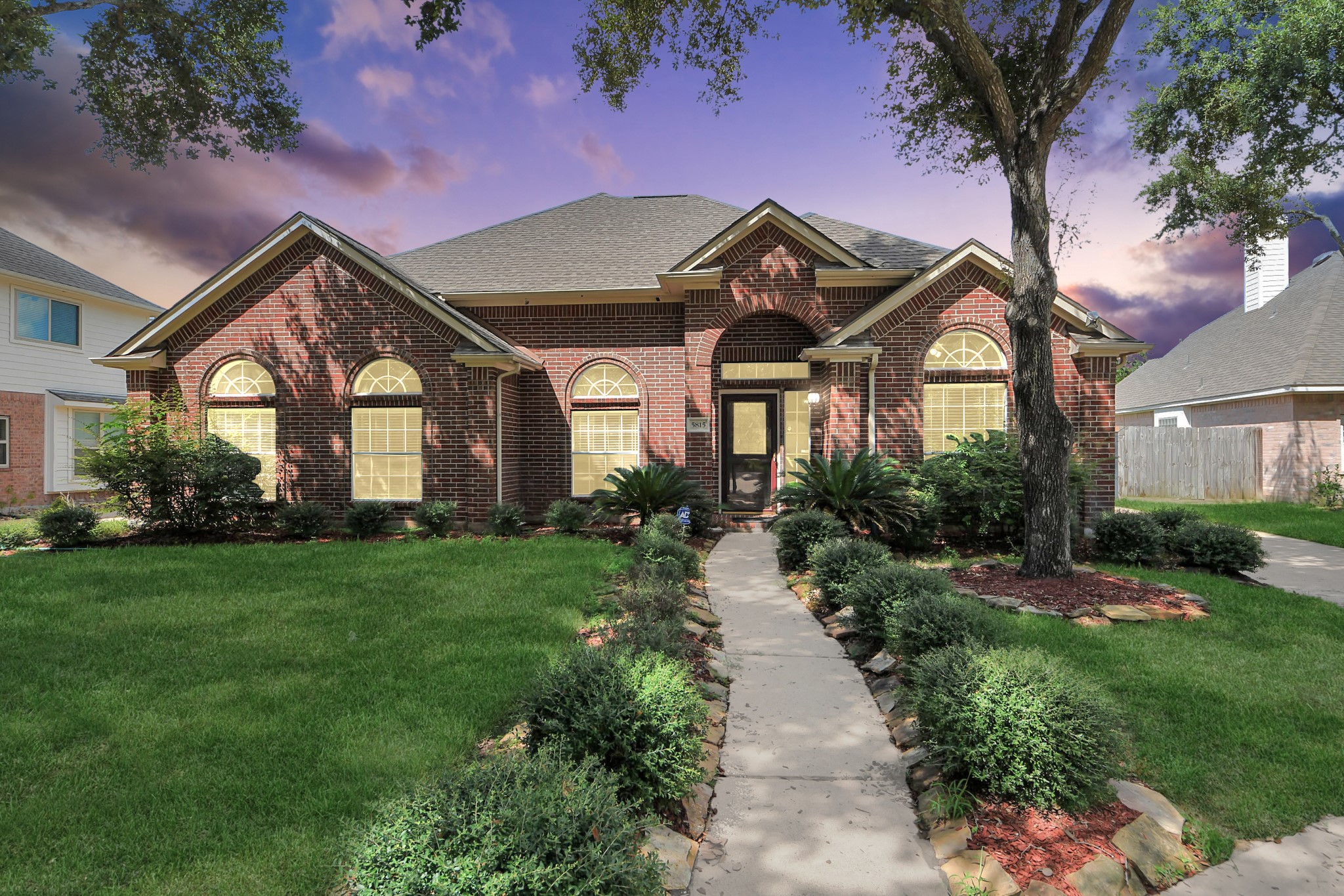 Charming brick home with a welcoming pathway, lush landscaping, and elegant arched windows, set against a picturesque sky. Charming brick home with a welcoming pathway, lush landscaping, and elegant arched windows, set against a picturesque sky.