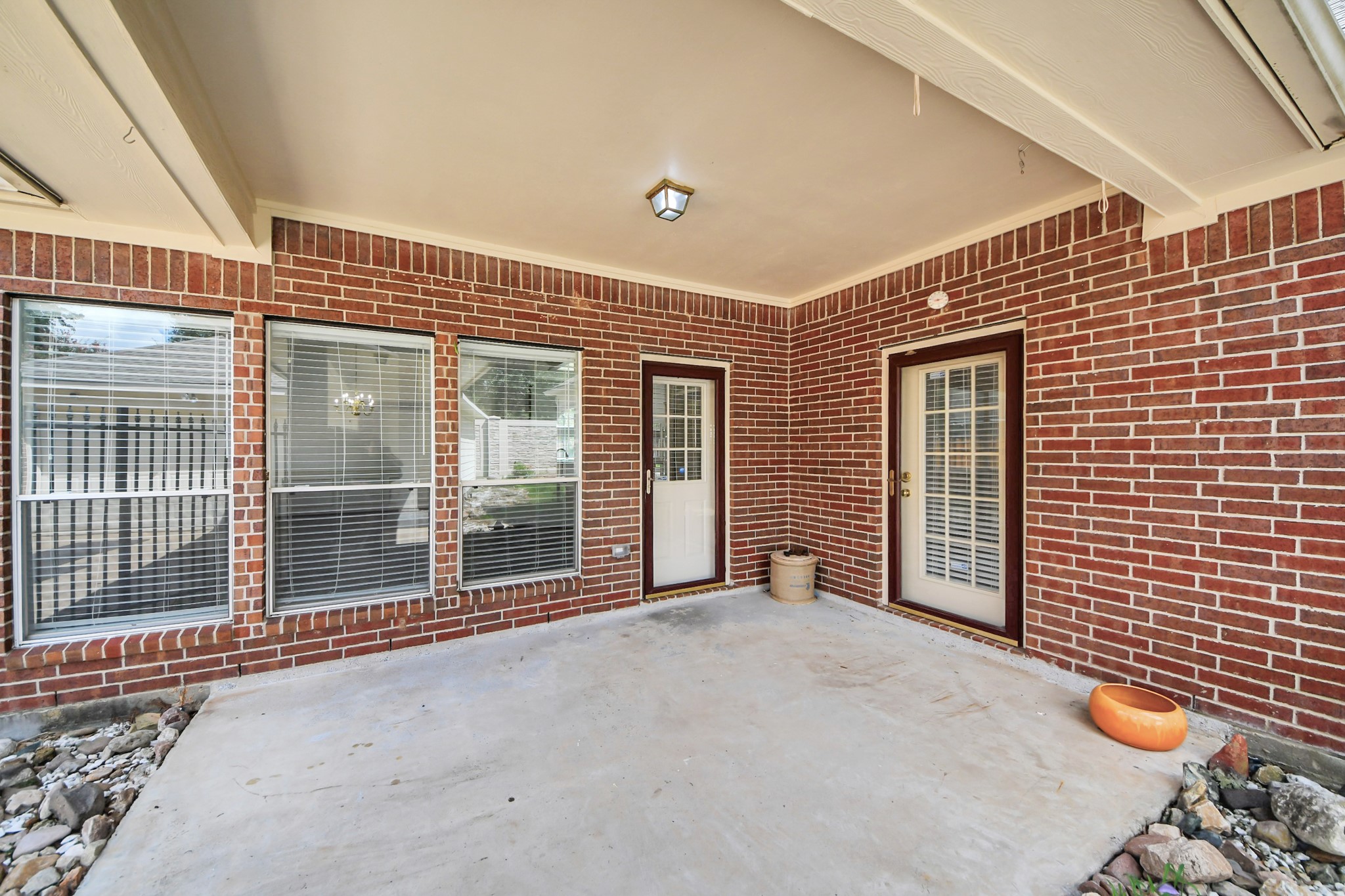 Charming brick patio with ample natural light, featuring dual French doors and large windows, perfect for relaxing or entertaining.