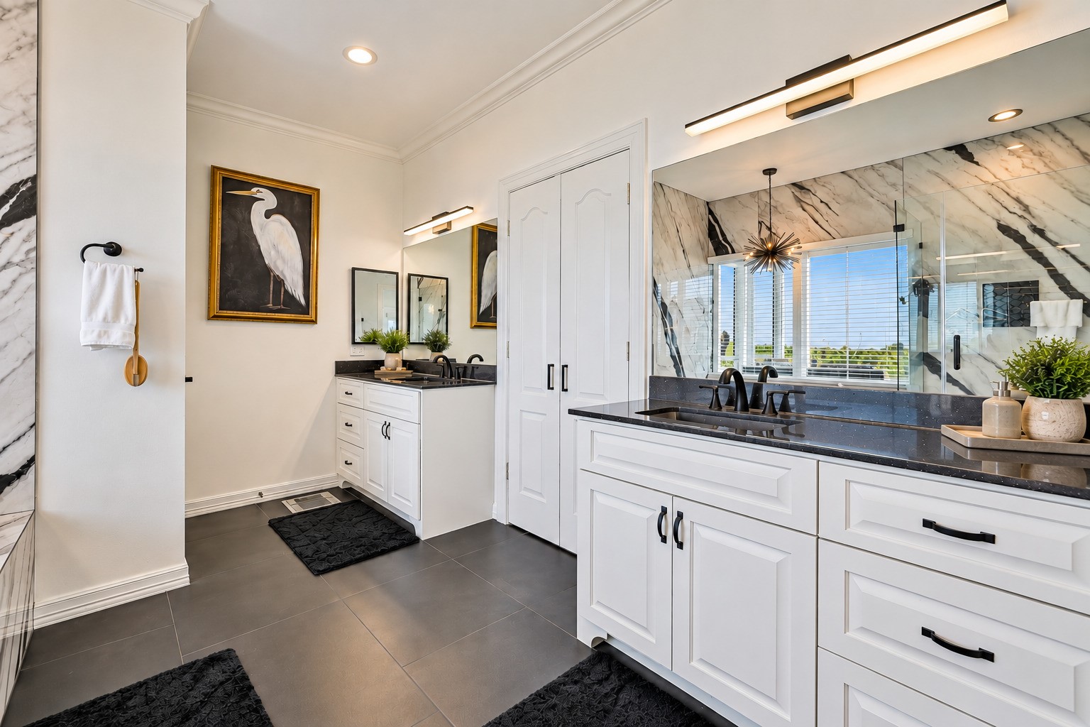 Floor-to-ceiling custom tile work. Black-framed modern glass shower doors. Shower niche built into the wall. Poured granite double sinks. A soaking jacuzzi tub positioned to enjoy the natural light. The primary bath at 12 Fleming was not updated  it was completely reimagined from scratch as part of the full 2025 luxury rebuild. The difference is visible in every single detail.