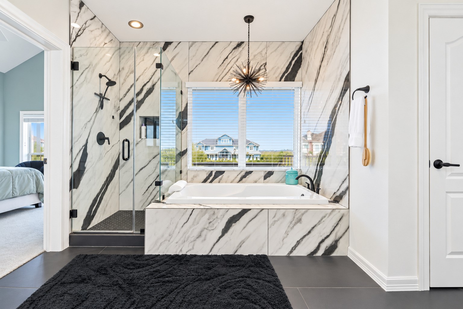 Jacuzzi tub, separate designer shower with floor-to-ceiling custom tile. Double vanities with poured granite sinks. Every finish in this primary suite was chosen with intention and installed new in 2025. The craftsmanship that defines the rest of this home does not stop at the bedroom door.