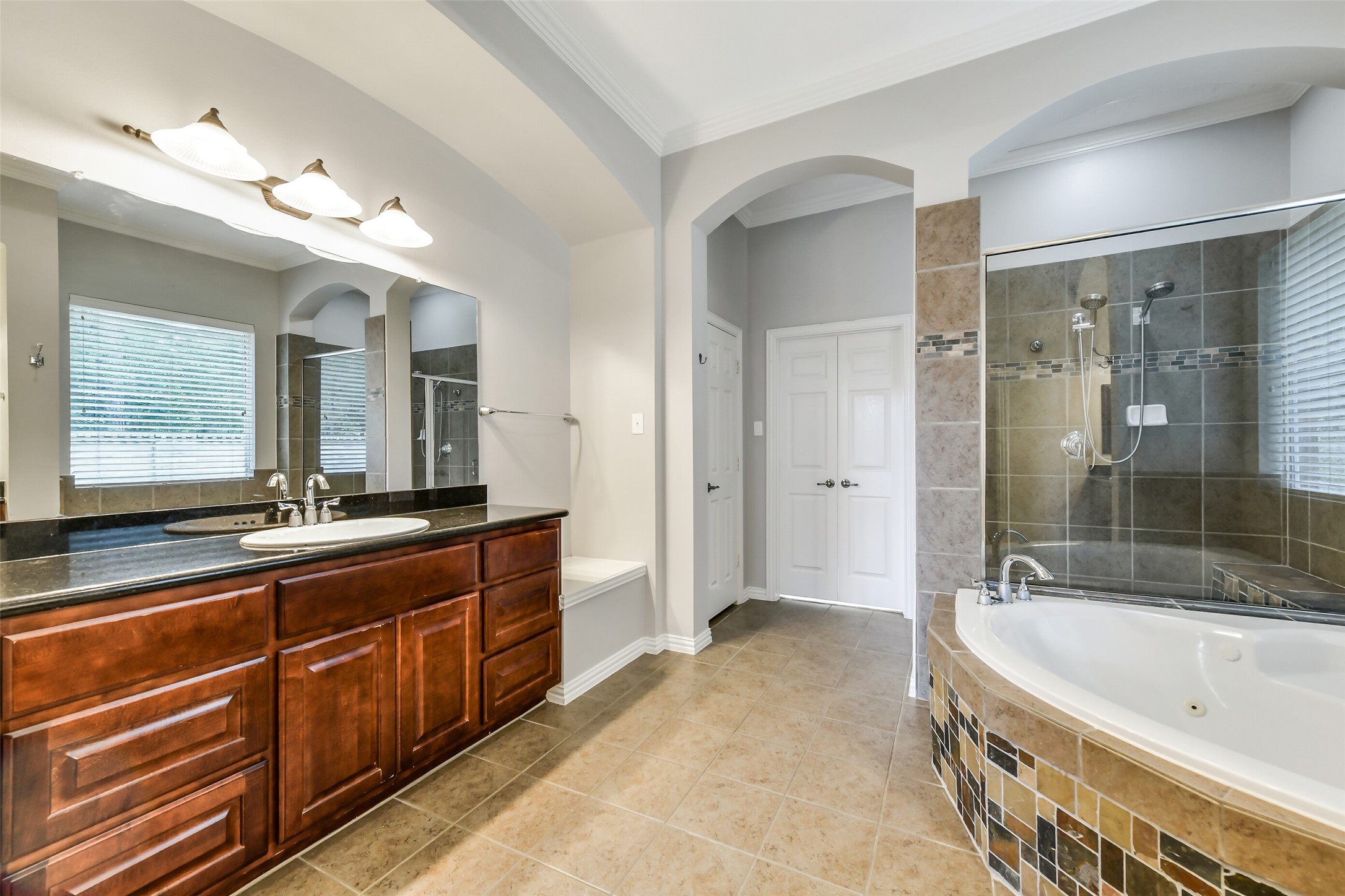 The spa-like primary bathroom boasts dual sinks and vanities, a relaxing soaking tub, and a spacious walk-in shower.