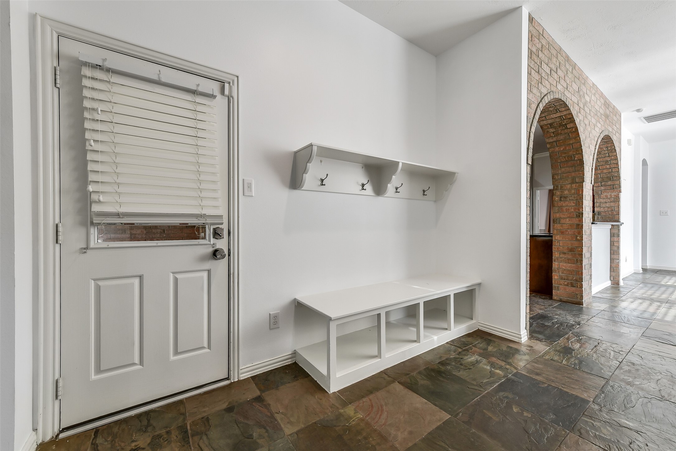 Conveniently located off the driveway entrance, this functional mudroom offers the perfect space to organize jackets, backpacks, and sporting gear.