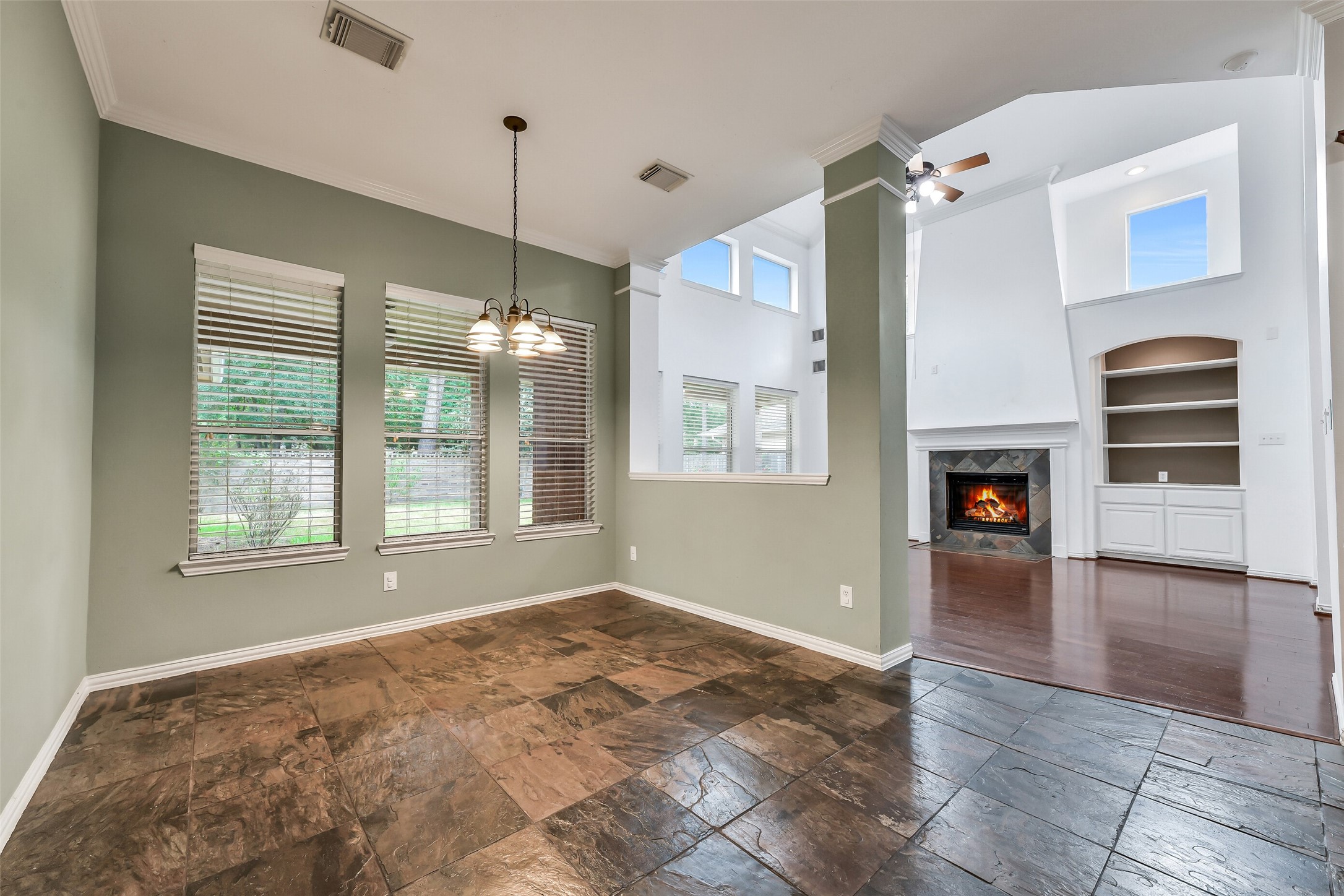 This view highlights the kitchen's stainless steel appliances, extra island storage, and an adjacent breakfast nook with pleasant views of the backyard.