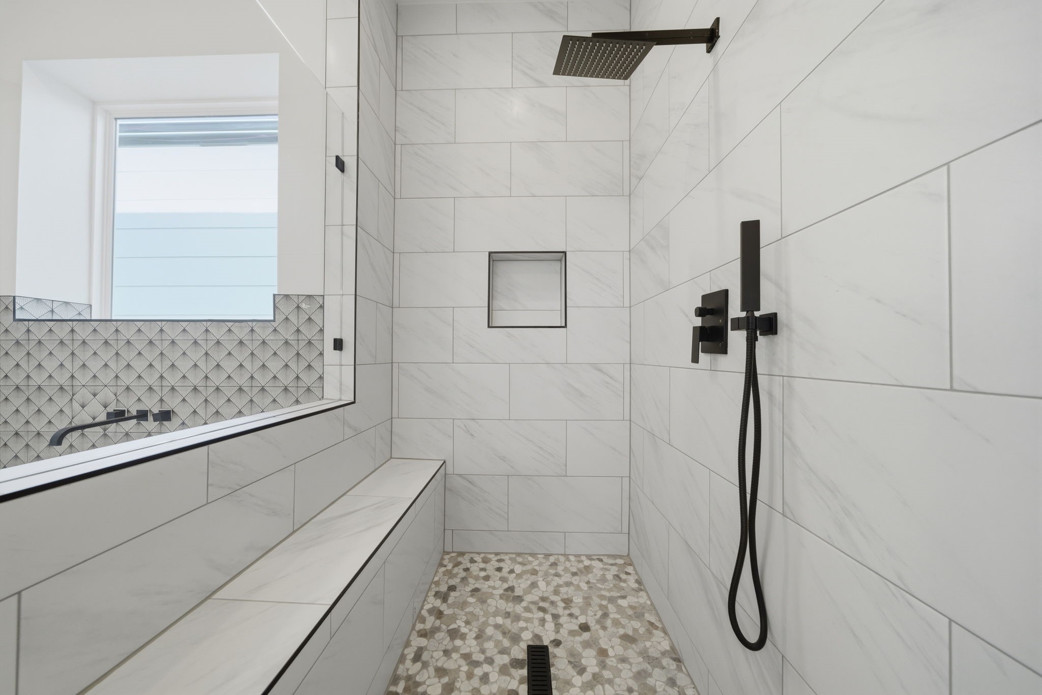 Spa-like primary bath features dual shower heads, shower seat, and tile extending to the ceiling. (Photos are of a previously completed home. Finishes are subject to change.)