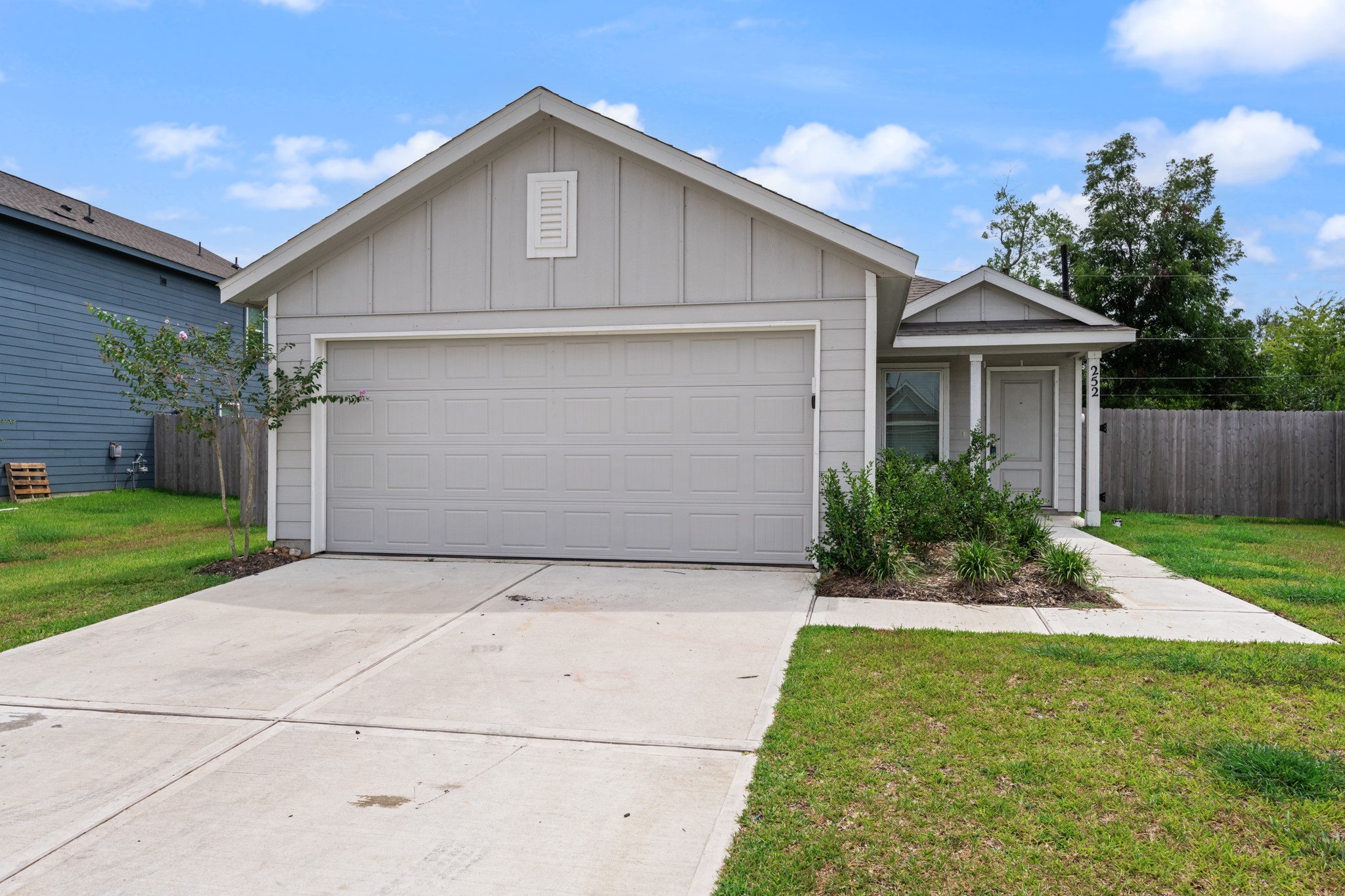 Welcoming single-story exterior with a two-car attached garage, covered front entry, and established landscaping. A wide concrete driveway and walkway provide convenient access to the home.