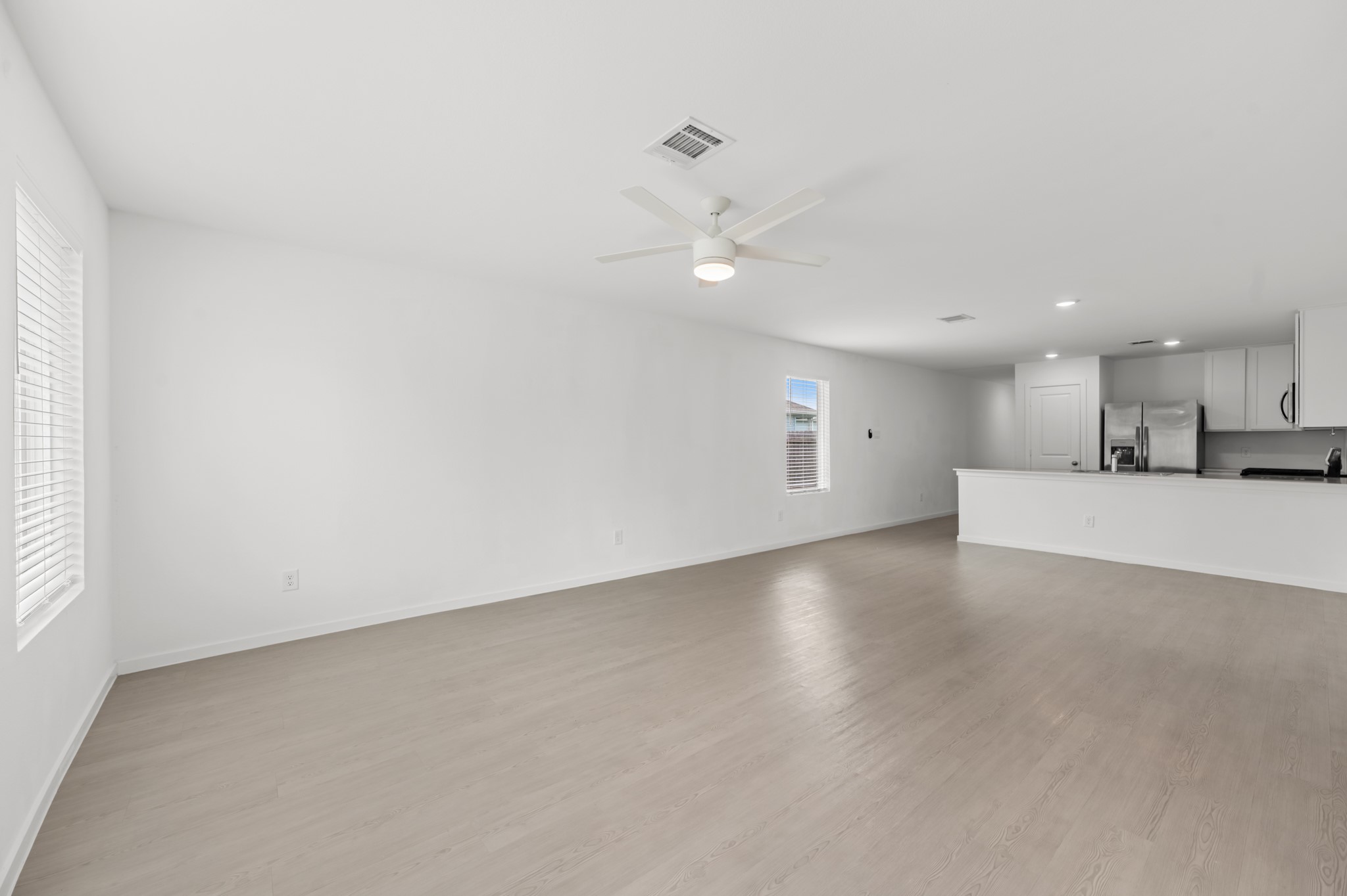 Wide-angle view showcases the seamless connection between the living room and kitchen, creating an open layout well suited for everyday living and entertaining.