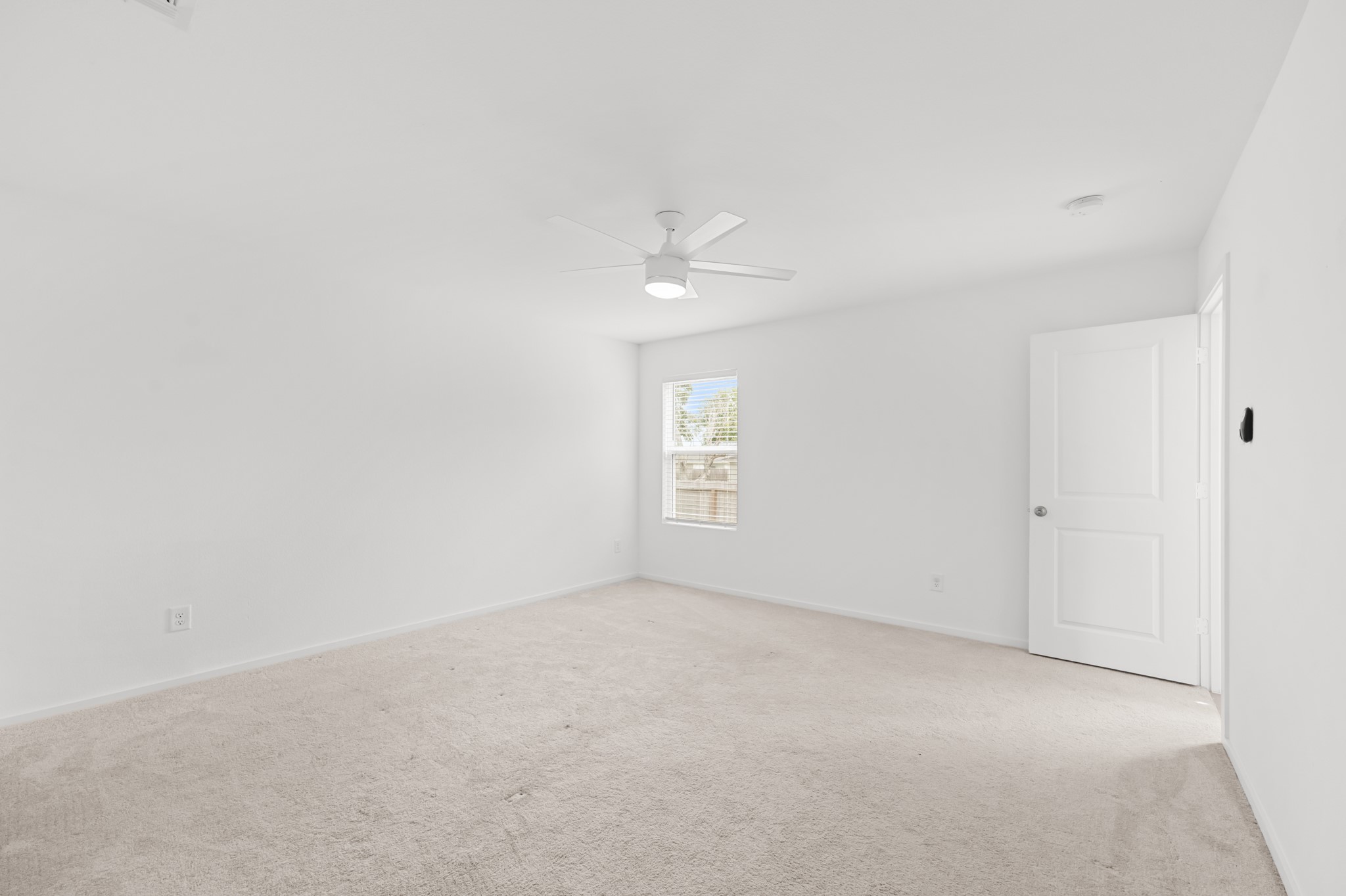 Alternate view showcases the primary bedrooms generous floor space, clean neutral finishes, and flexible wall space for furniture placement.