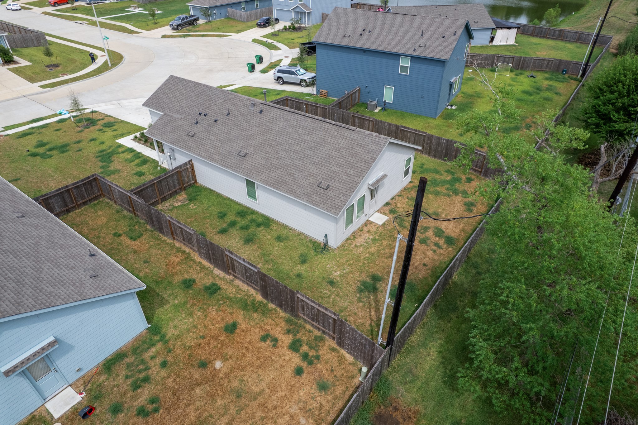Elevated rear view showcases the homes fenced backyard and surrounding outdoor space.