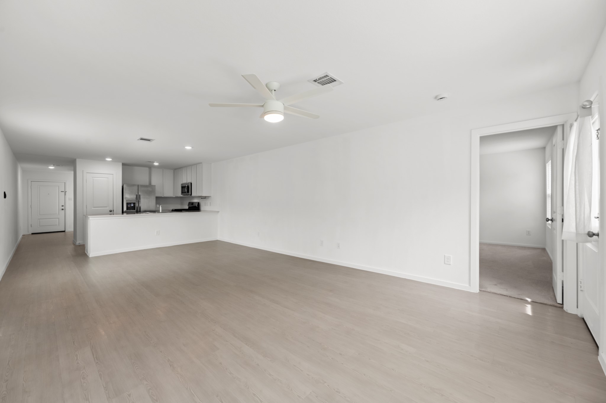Alternate view highlights the open connection between the living area and kitchen, with the peninsula helping define each space while maintaining an easy flow.