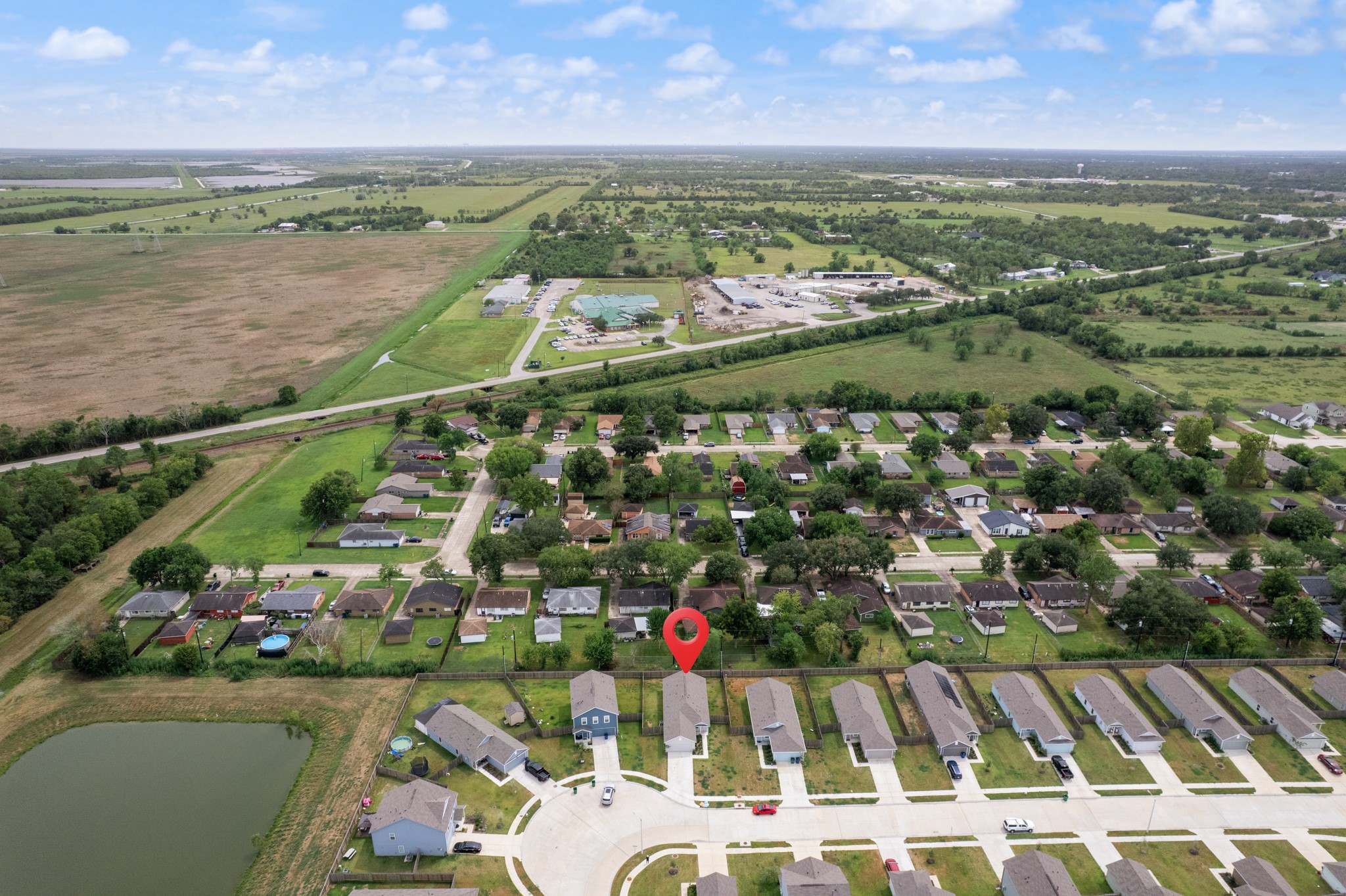 Wide aerial view shows the propertys setting within the surrounding residential area, with the home identified for easy reference.