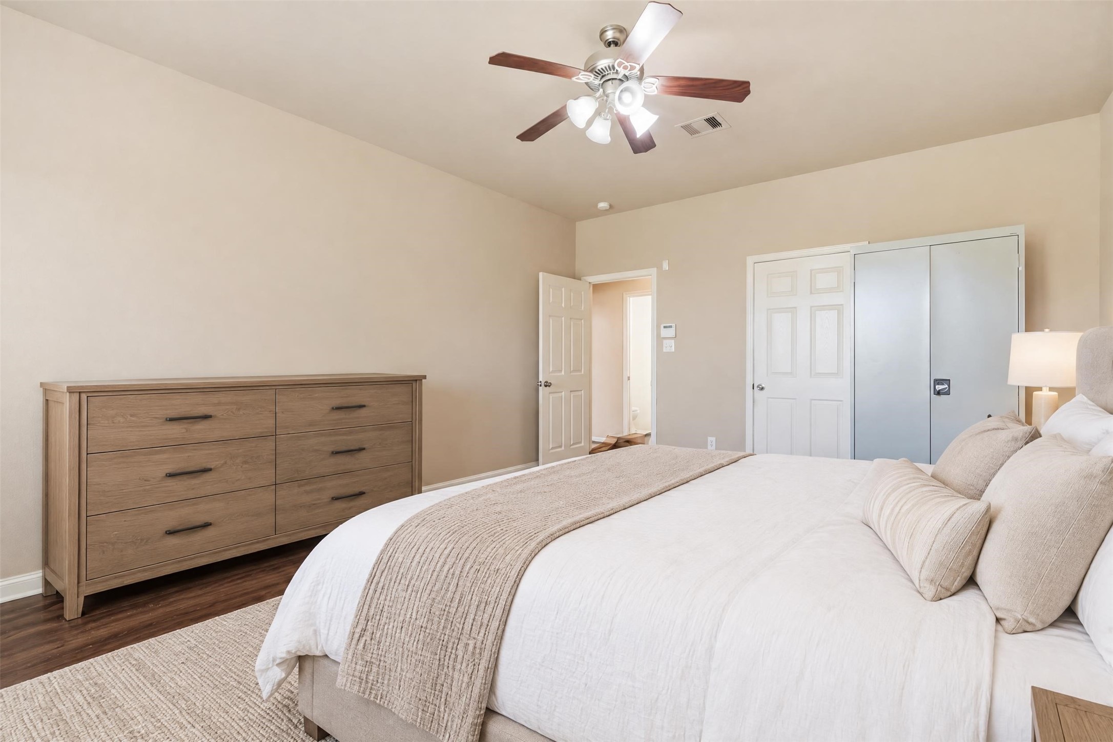 Virtually staged. Another view of the primary suite showing its generous layout and easy access to the ensuite bath and walk-in closet.