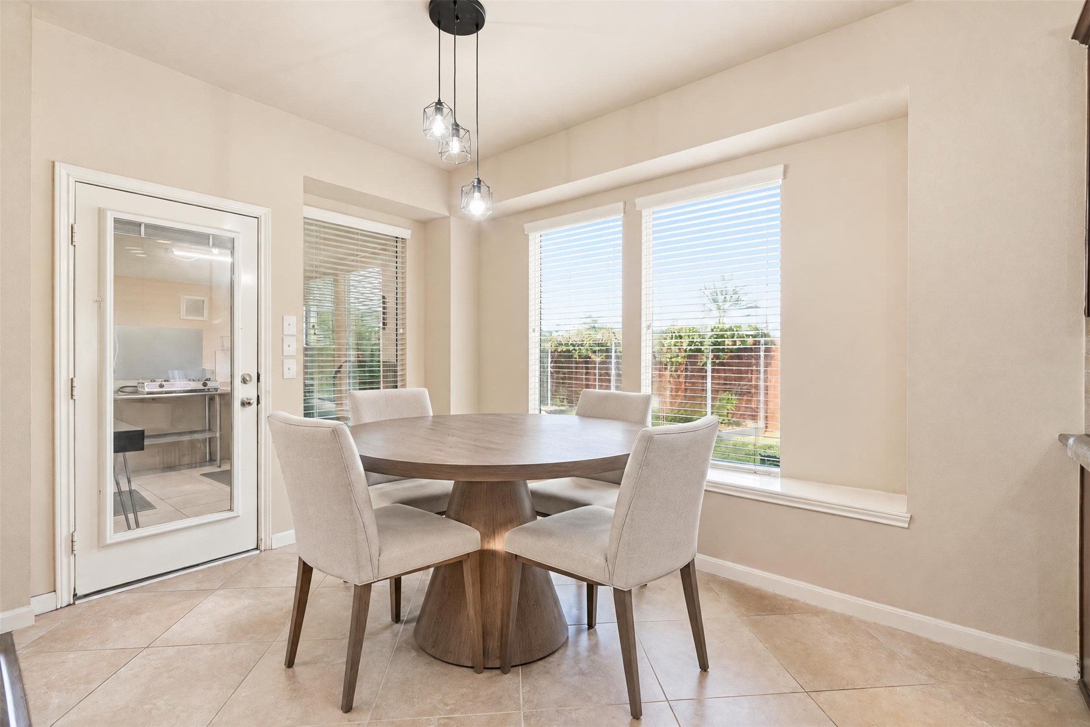 Virtually staged. A sunny breakfast nook with backyard views and a door straight into the enclosed spice kitchen. A bright, easy spot for morning coffee.