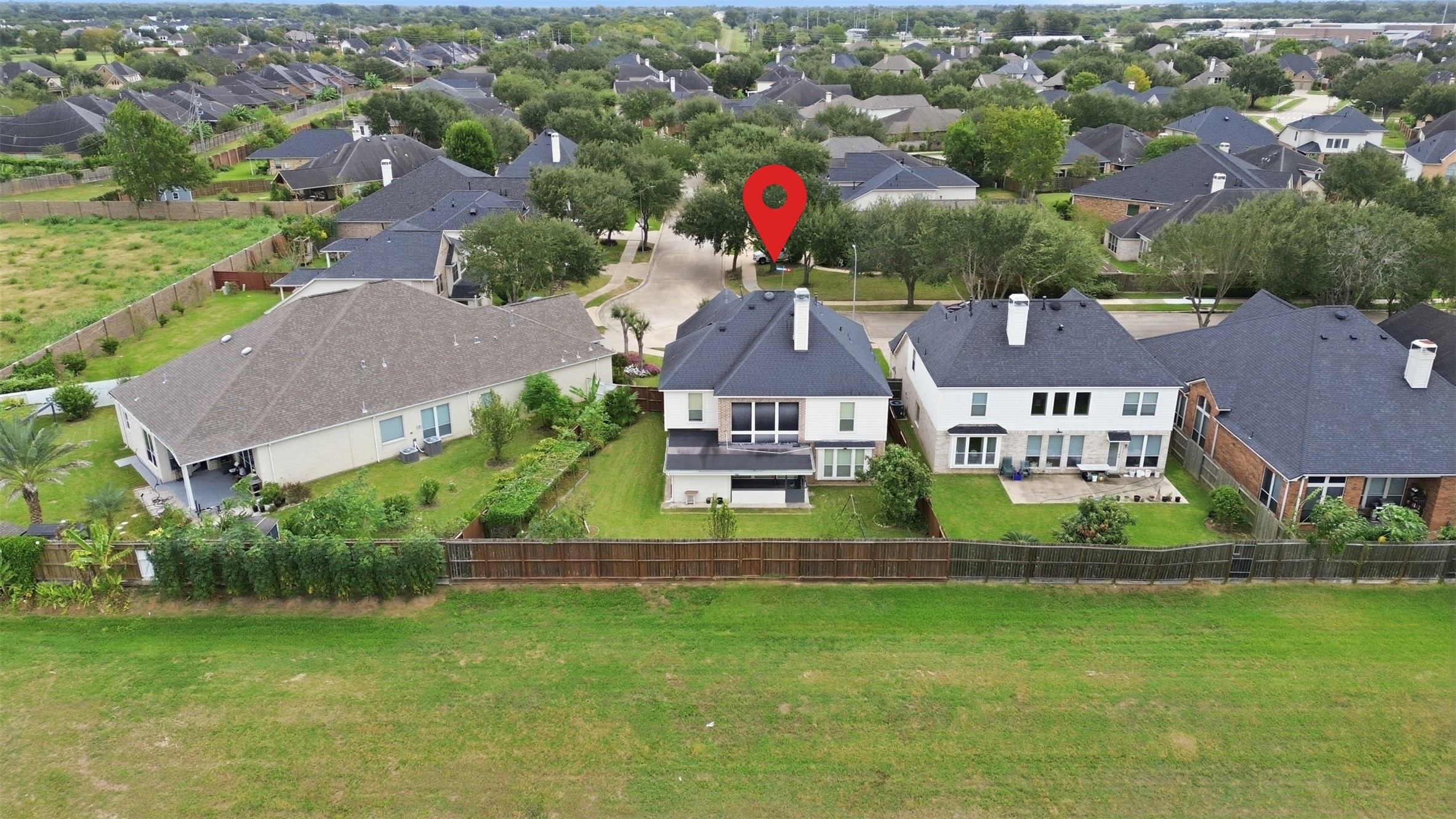 From behind the home you can see what makes this lot special: open green space instead of a neighbors backyard, with mature trees lining the quiet streets of Riverstone.