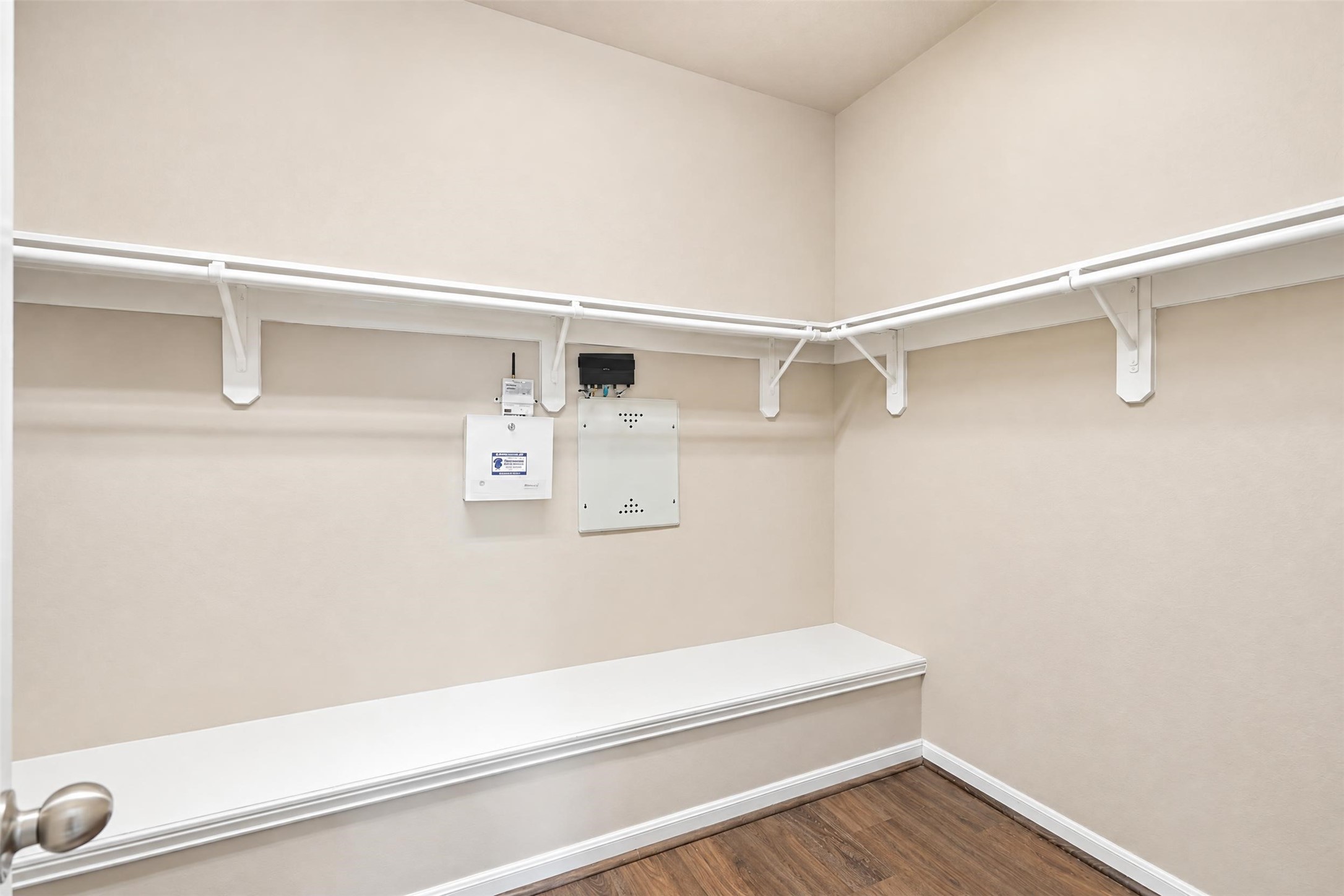 A generous walk-in closet with built-in shelving and a bench, so wardrobes and shoes have a proper place.