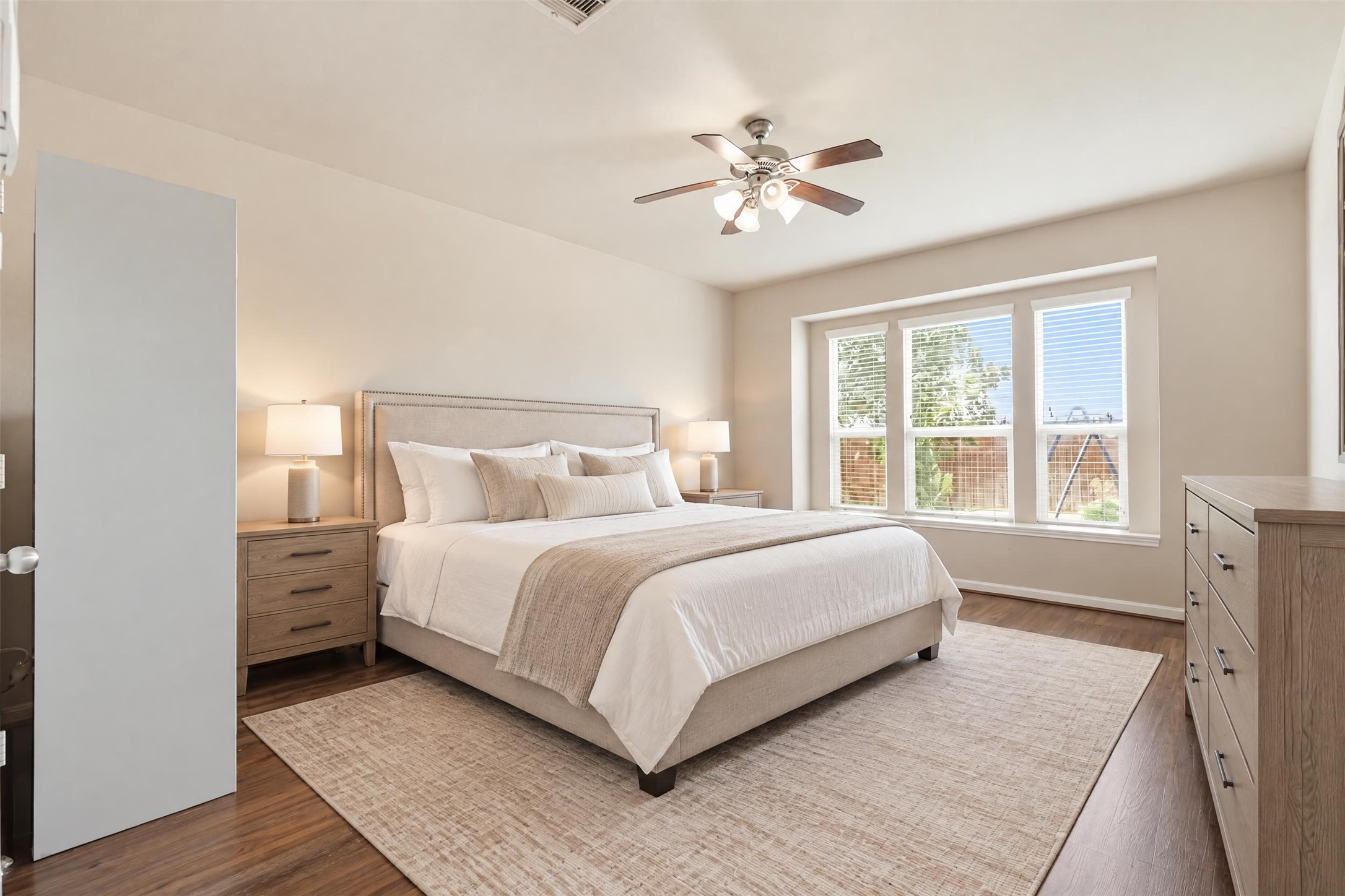 Virtually staged. The primary suite is on the main floor and set apart from the upstairs bedrooms for privacy, with about 13'8" x 16'11" of space for a king bed and a sitting area.