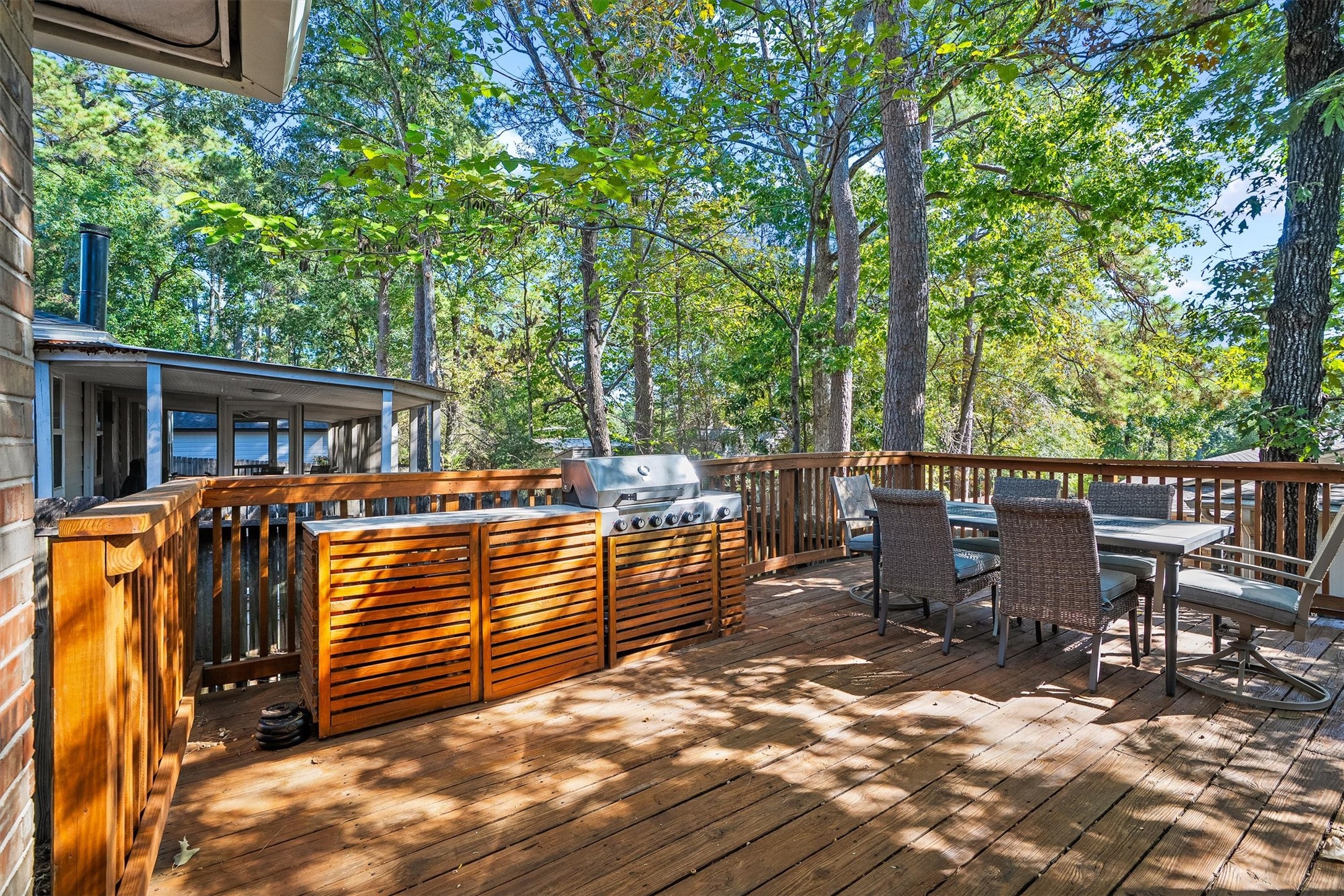 The built-in grill station with wood slat cabinetry makes this deck the go-to spot for weekend cookouts, with an exterior gas connection already in place.