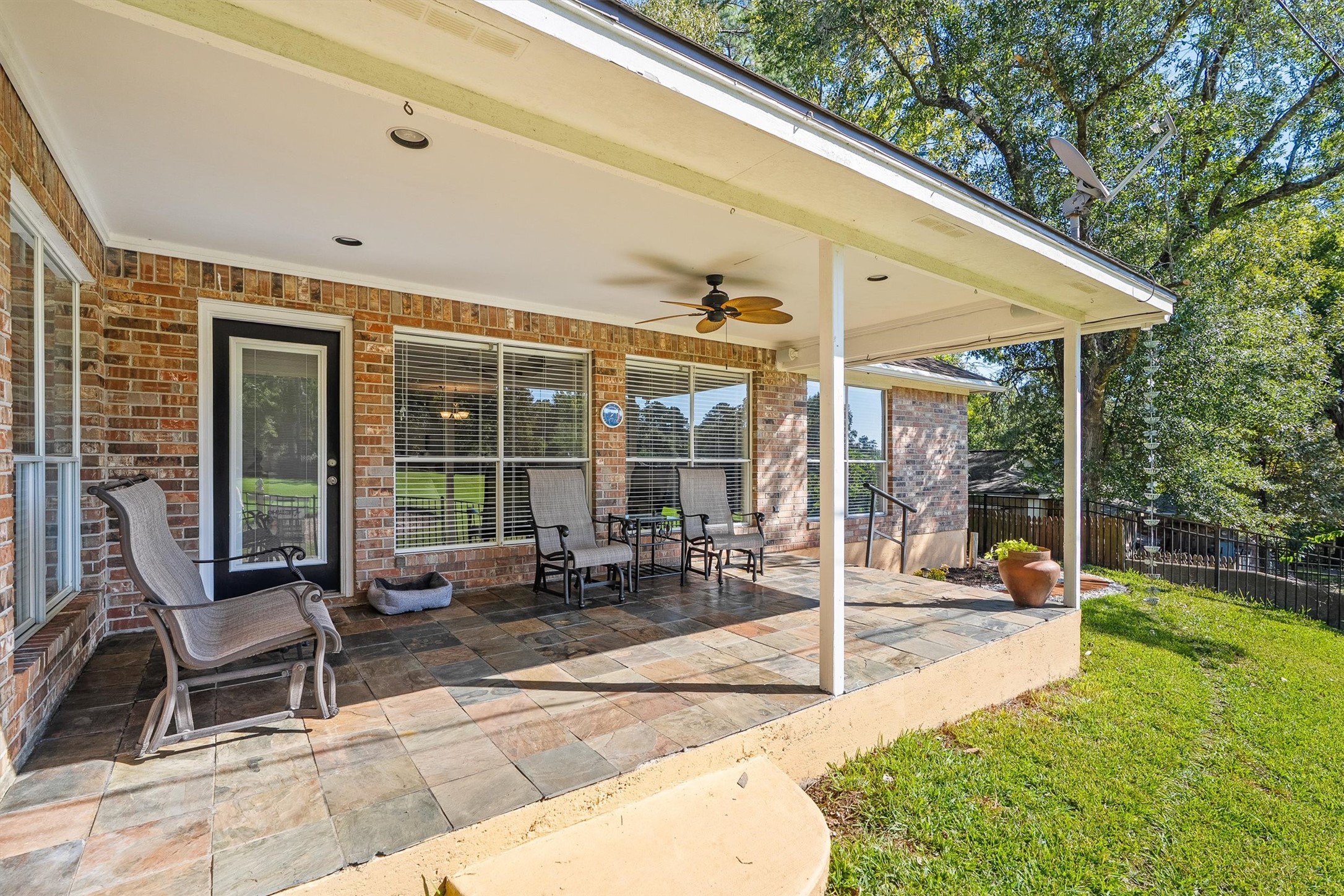 Up close, the covered patio shows off its stone tile flooring and recessed lighting, so morning coffee easily turns into an evening hangout.