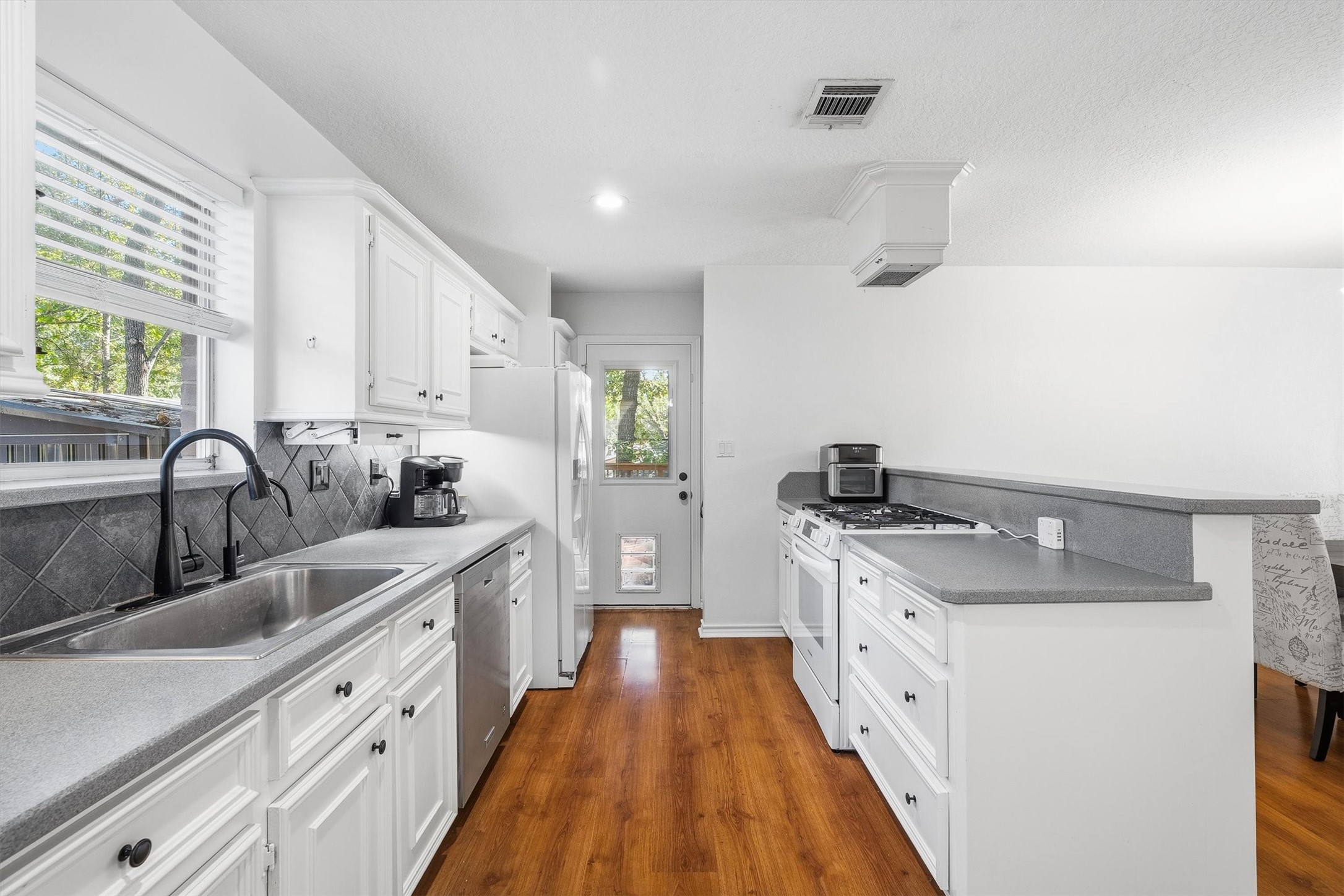 The gas range sits along the breakfast bar, so whoevers cooking can keep chatting with guests on the other side. At the end of the galley, the back door comes with a built-in pet door, letting the four-legged members of the household come and go on their own schedule.