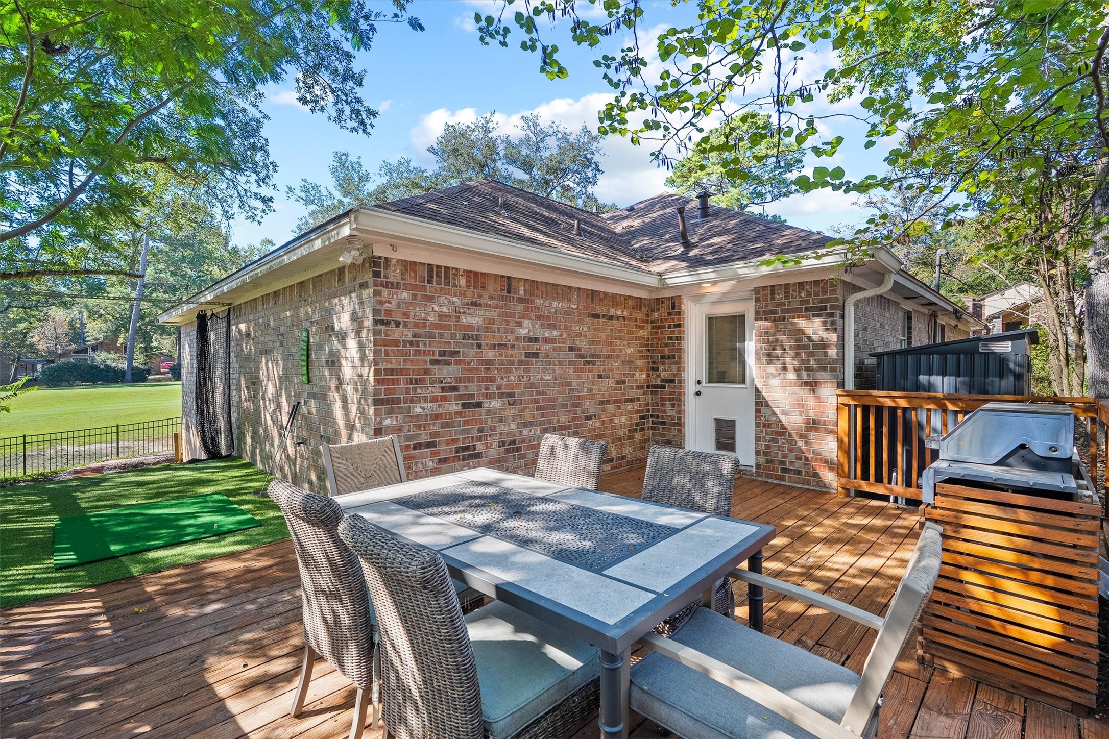 Around the side, a spacious wood deck sits under mature shade trees, giving you a second outdoor living area for alfresco dinners.