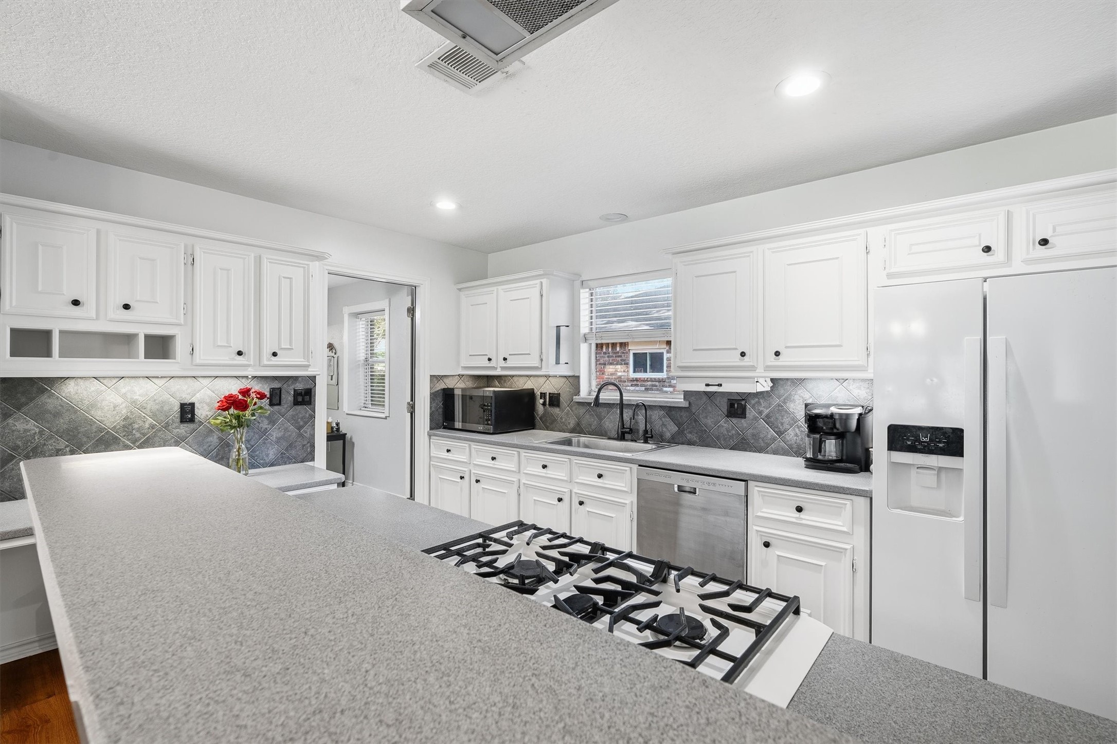 Silestone countertops stretch across this kitchen, giving you plenty of room to prep, plate, and still have space for the coffee maker.
