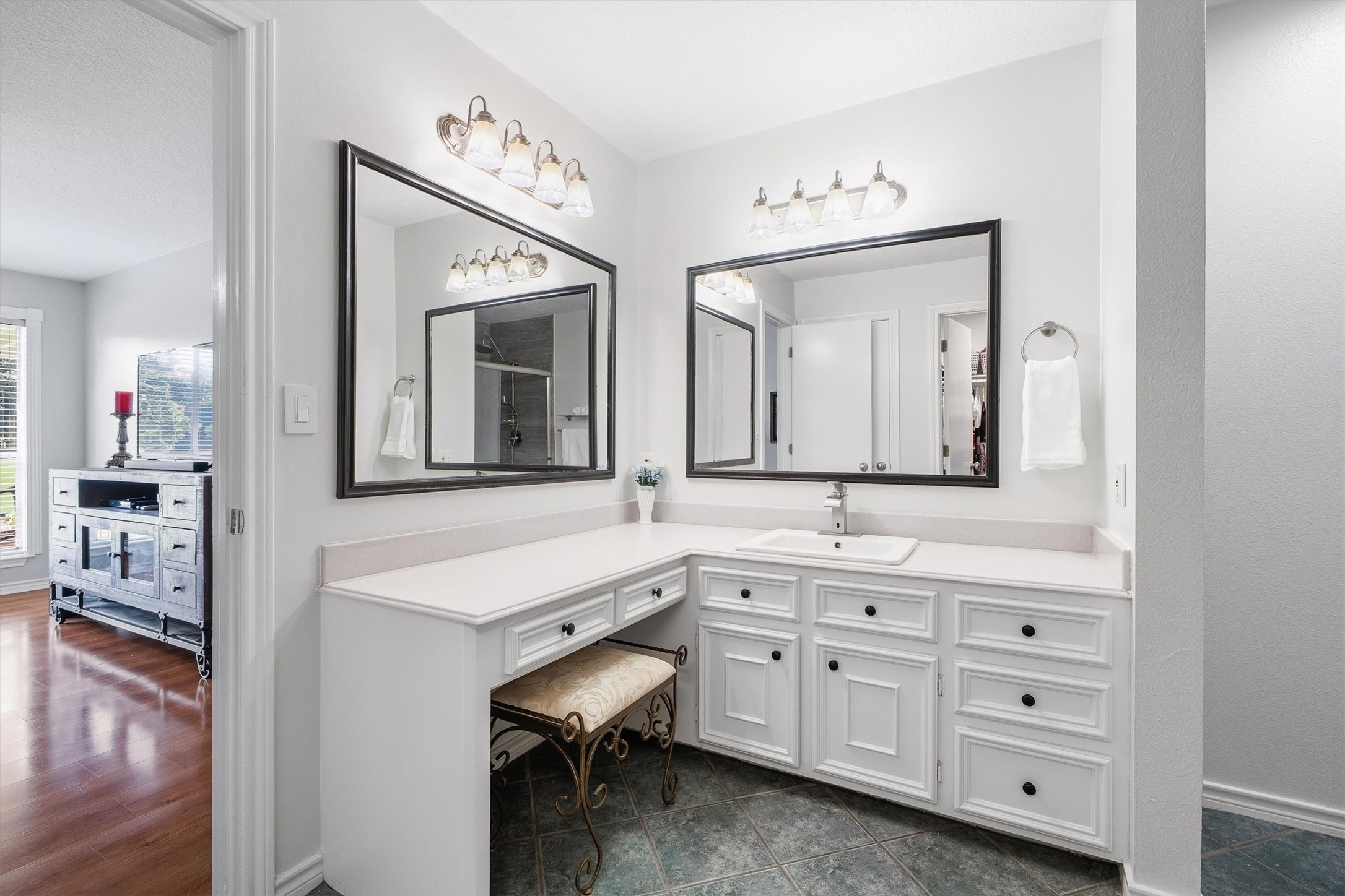 A built-in seated vanity gives you a dedicated spot to get ready, with plenty of drawer space for everything that usually crowds the counter.