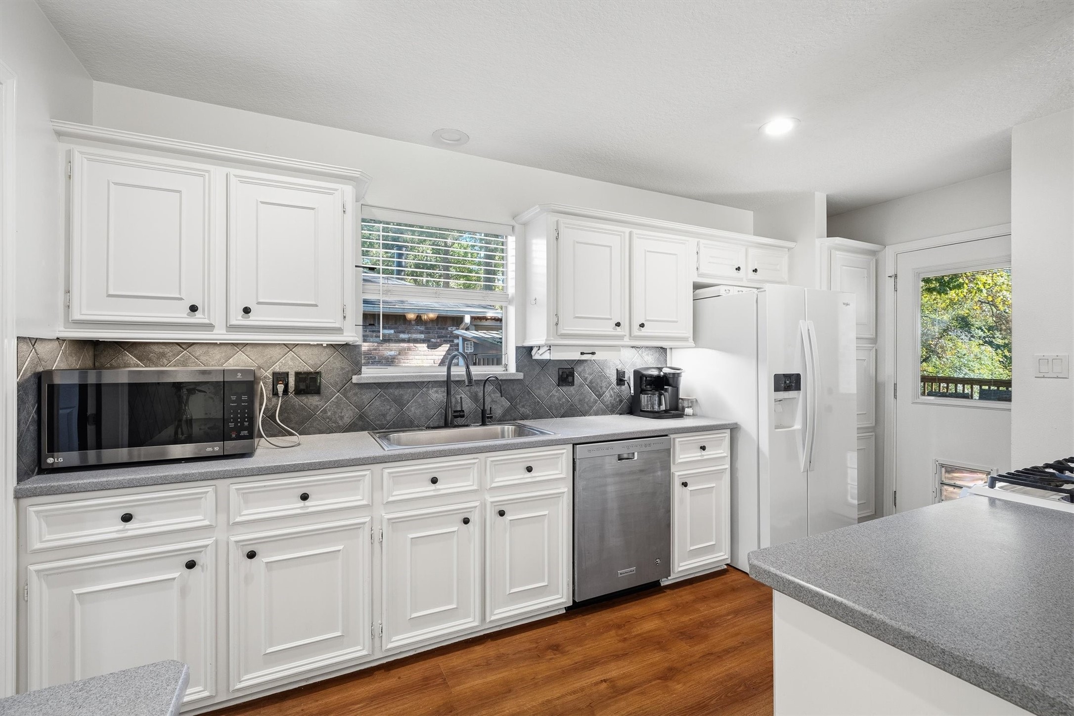 Under-cabinet lighting keeps the counters bright for early-morning coffee and late-night snacks, while the window over the sink brings in a little daylight too.