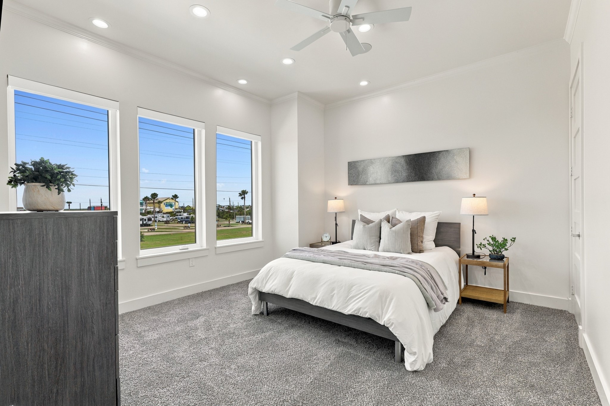 Secondary bedroom
Sun-filled secondary bedroom with three tall windows, soft carpeting, and a neutral palette. Recessed lighting and a ceiling fan complete this comfortable retreat.