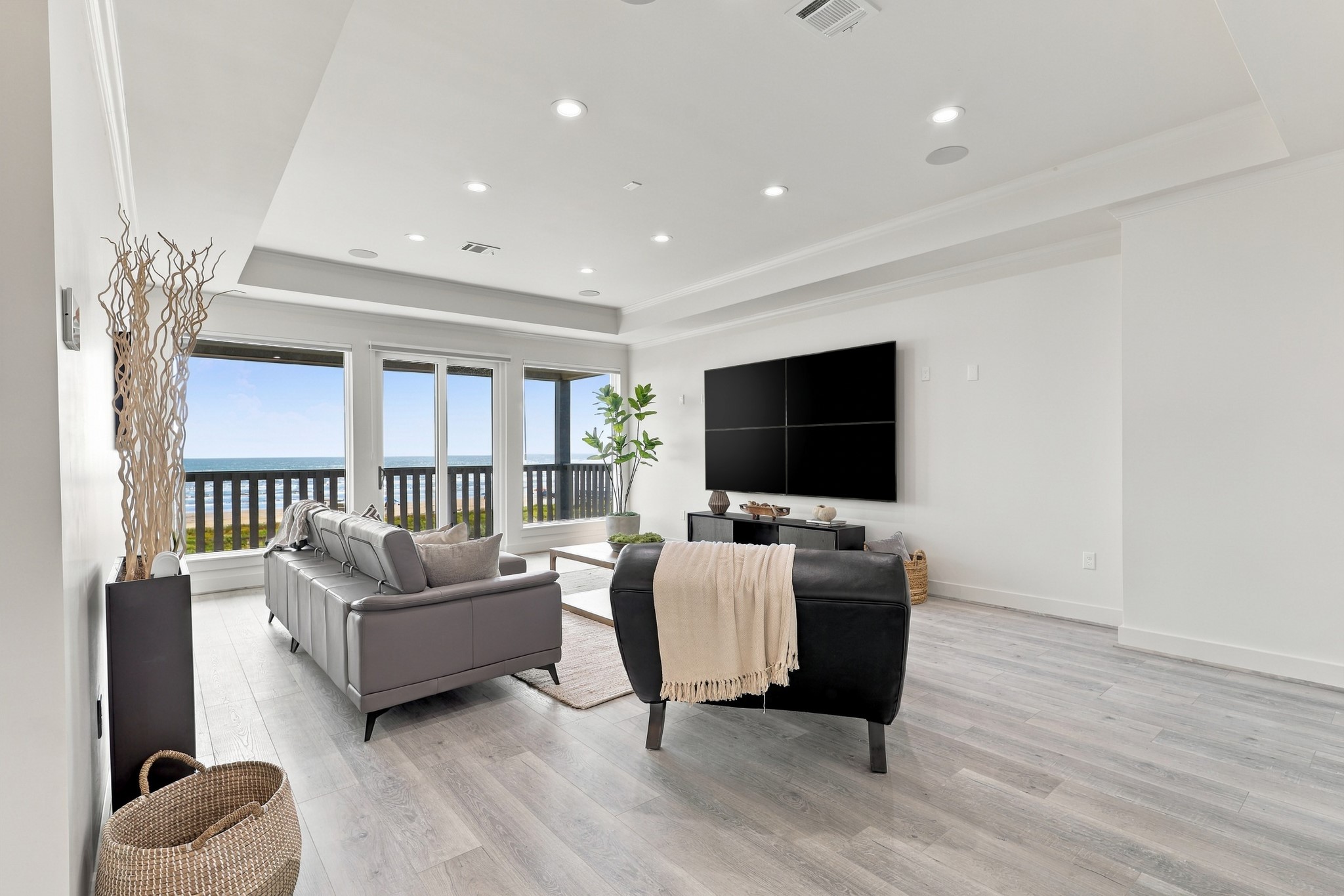 Additional Gulf-facing living area
A separate living area offers another inviting place to relax, with expansive Gulf views and sliding glass doors opening to a covered deck. A tray ceiling adds architectural definition.

Photo 26  Additional living area, reverse view