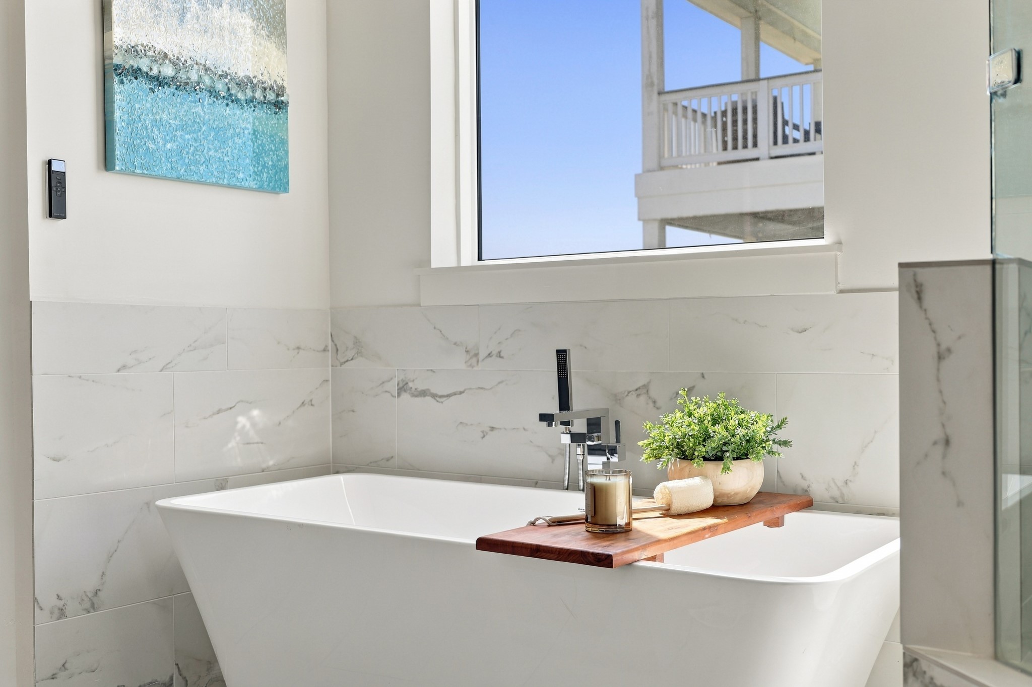 Freestanding soaking tub
Unwind in the freestanding soaking tub, complemented by a floor-mounted chrome faucet and elegant marble-look tile. Natural light enhances the bathrooms calm, airy atmosphere.