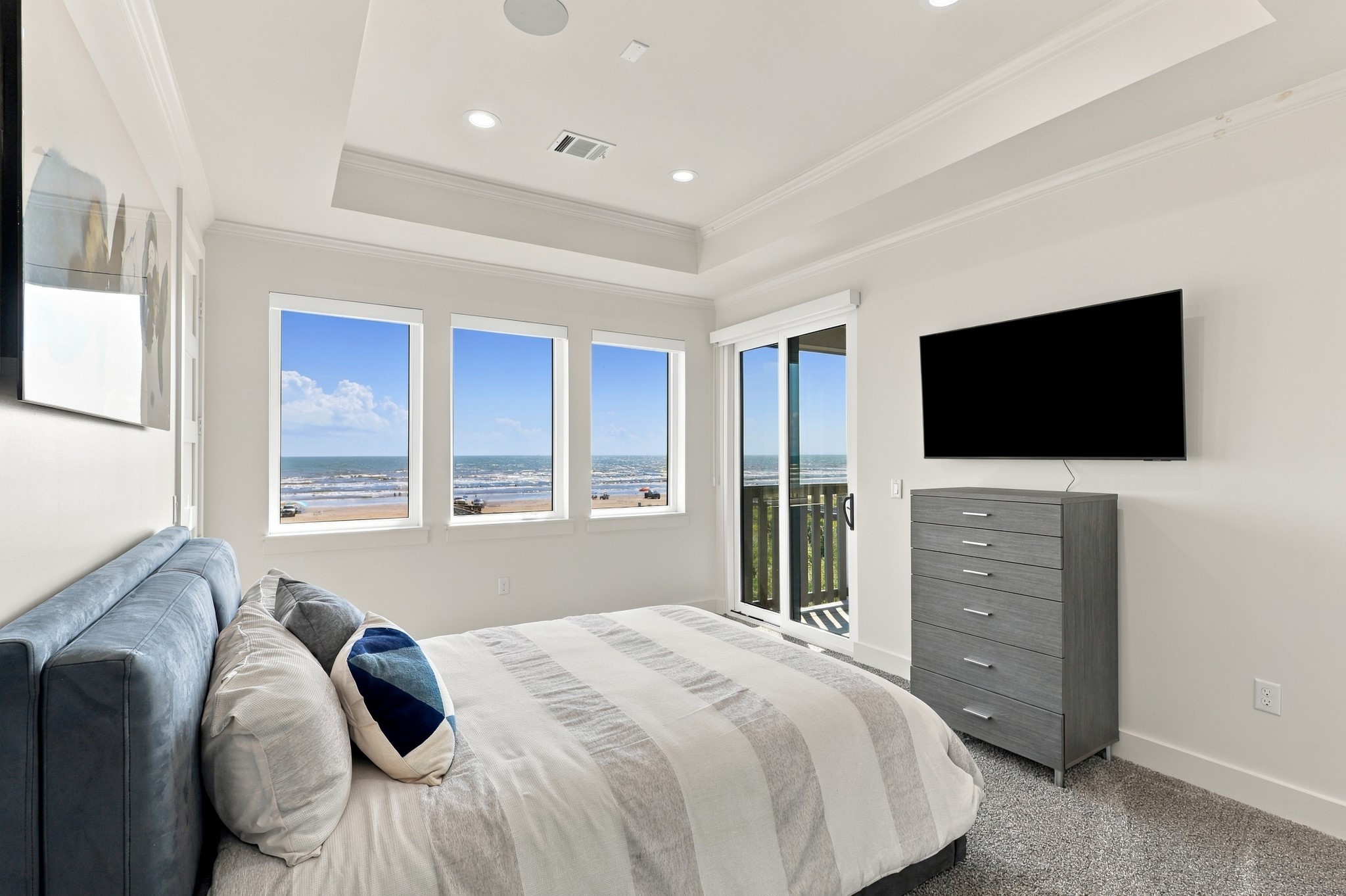 5th Gulf-view bedroom
Wake to sweeping Gulf views in this inviting bedroom, featuring three beachfront windows and direct access to a covered balcony. A tray ceiling and soft carpeting complete the peaceful retreat.