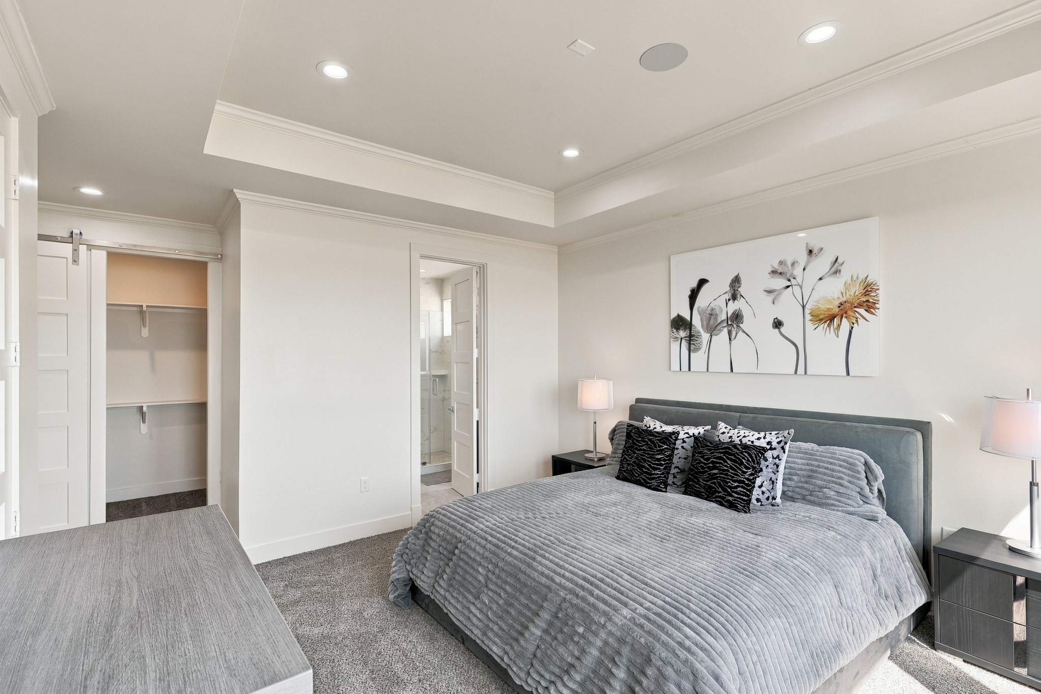 Forth Gulf-view bedroom, alternate view
This reverse perspective highlights the bedrooms spacious layout, closet shelving, and access to an adjoining bathroom. Crown molding and a layered tray ceiling bring architectural interest to the retreat.