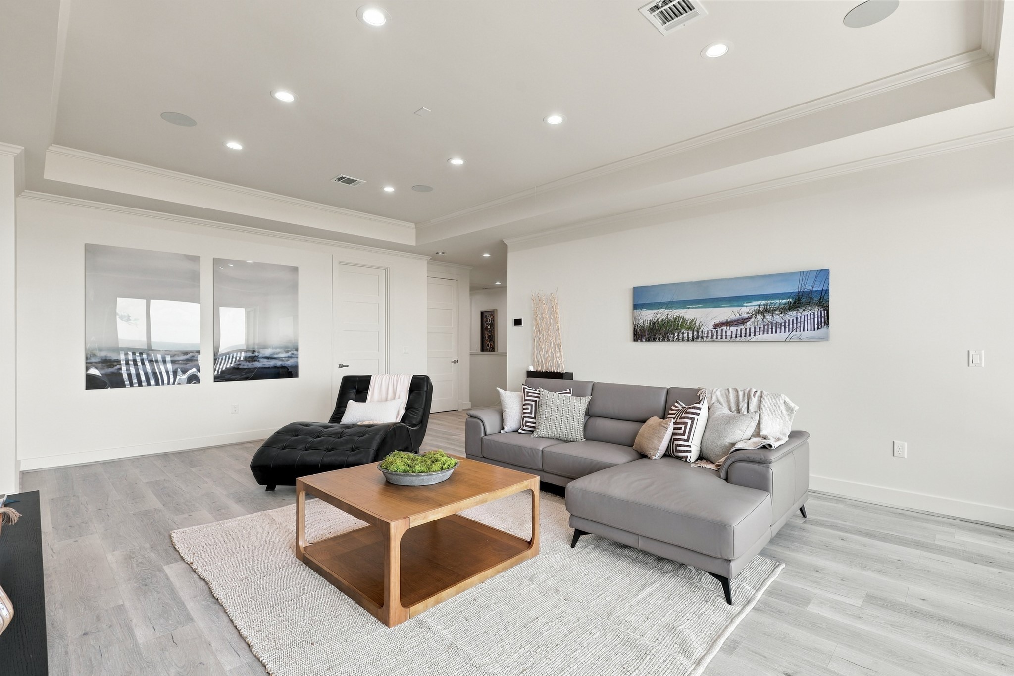 Additional Family area, reverse view
This reverse view showcases the additional living areas spacious layout, recessed lighting, and cohesive coastal finishes. Plenty of room to gather, unwind, or enjoy a movie night.
