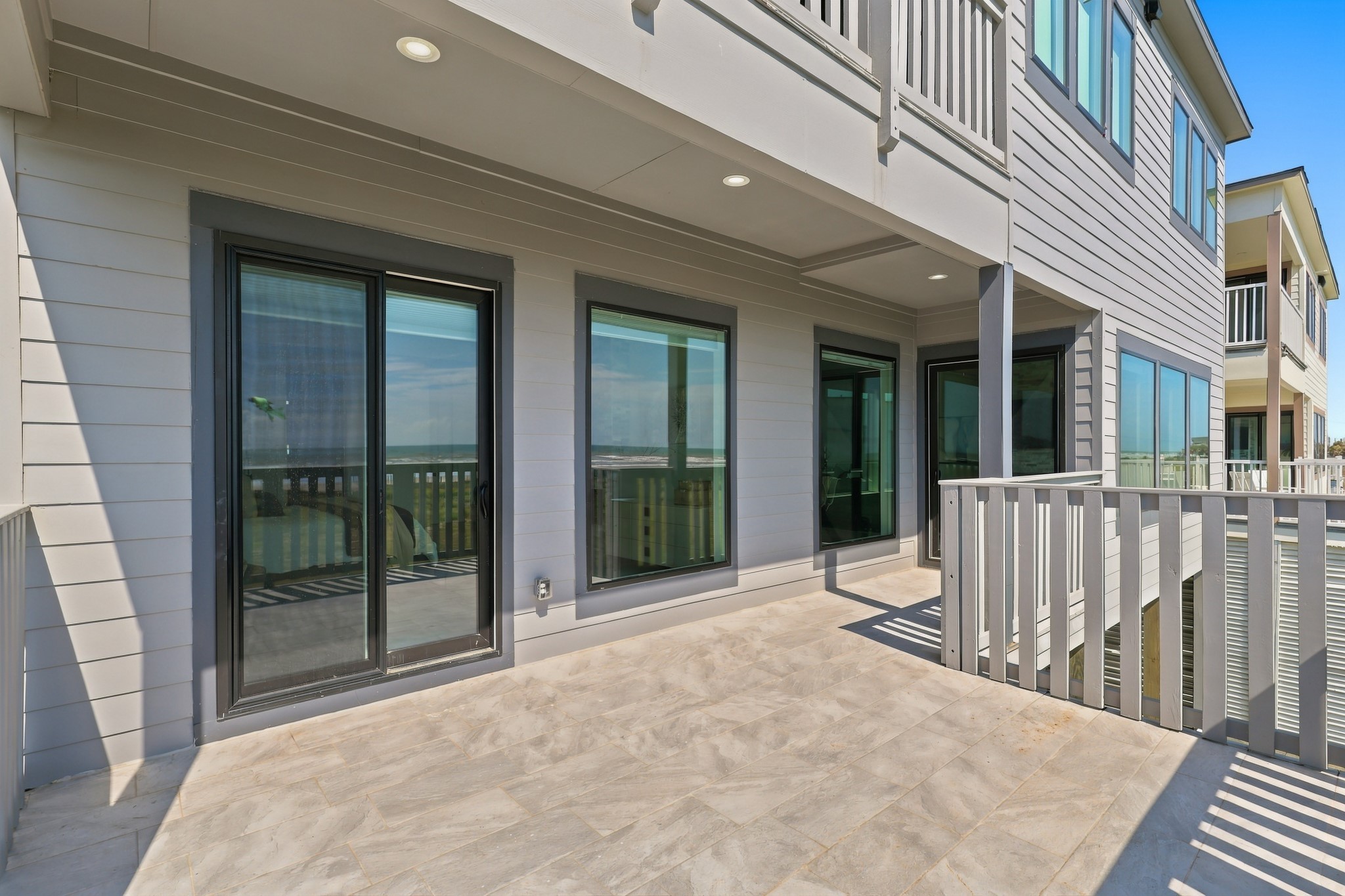 Covered deck
A spacious covered deck extends the living space outdoors, with recessed lighting and large glass doors connecting to the interior. An inviting setting for lounge seating and coastal entertaining.
