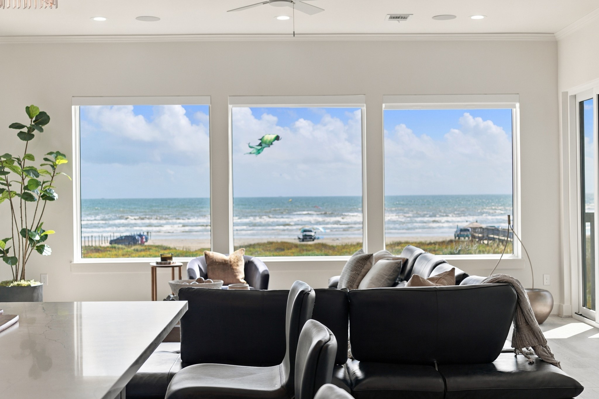 Living room Gulf views
Three expansive picture windows showcase the beach and Gulf beyond. The open connection between the kitchen and living area keeps the waterfront scenery in view while cooking, gathering, or relaxing.