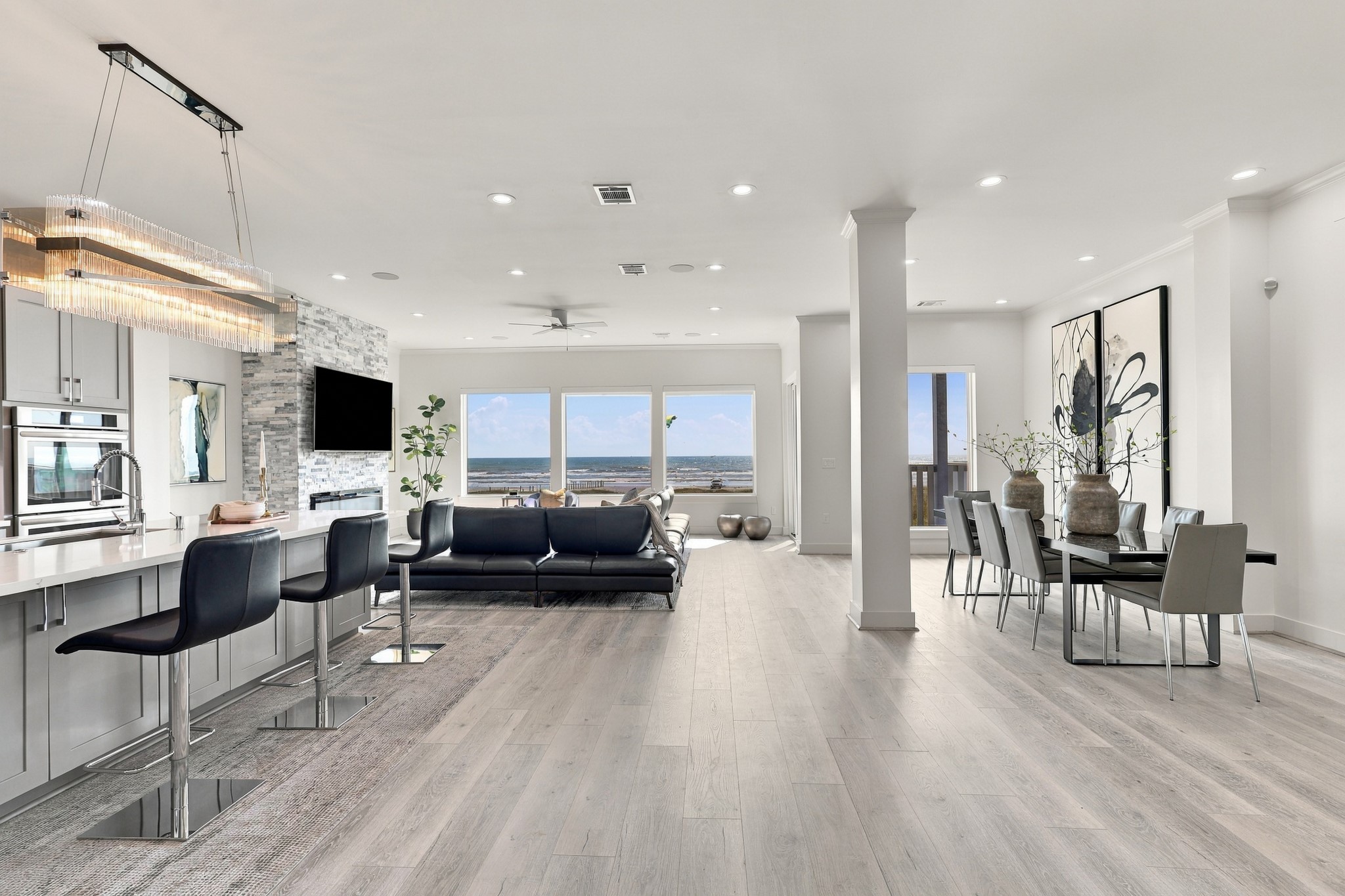 Expansive Gulf views anchor this open living space, where the kitchen, dining area, and living room flow together beautifully. A light coastal palette complements the waterfront setting.