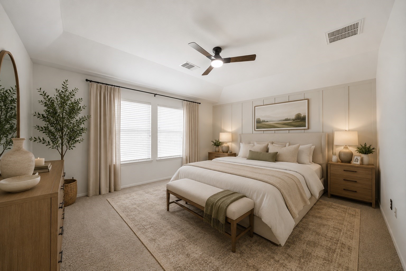 Enhanced by a tray ceiling and custom board-and-batten accent wall, this primary bedroom showcases carpet flooring and dual windows. Generous proportions easily accommodate a full furniture suite, while an expansive walk-in closet sits nearby. This photo has been virtually staged.
