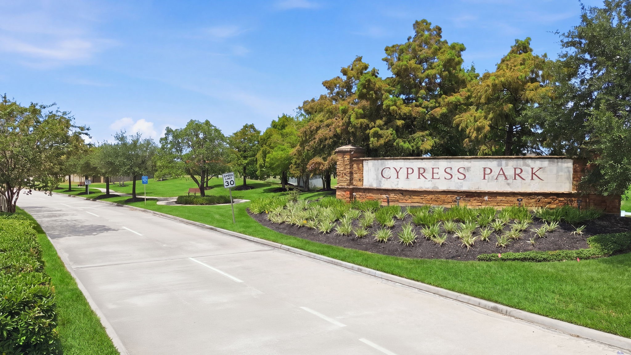 Cypress Park stone monument sign marks the entrance to Cypress Landing, highlighting a landscaped boulevard in a rapid growth area.