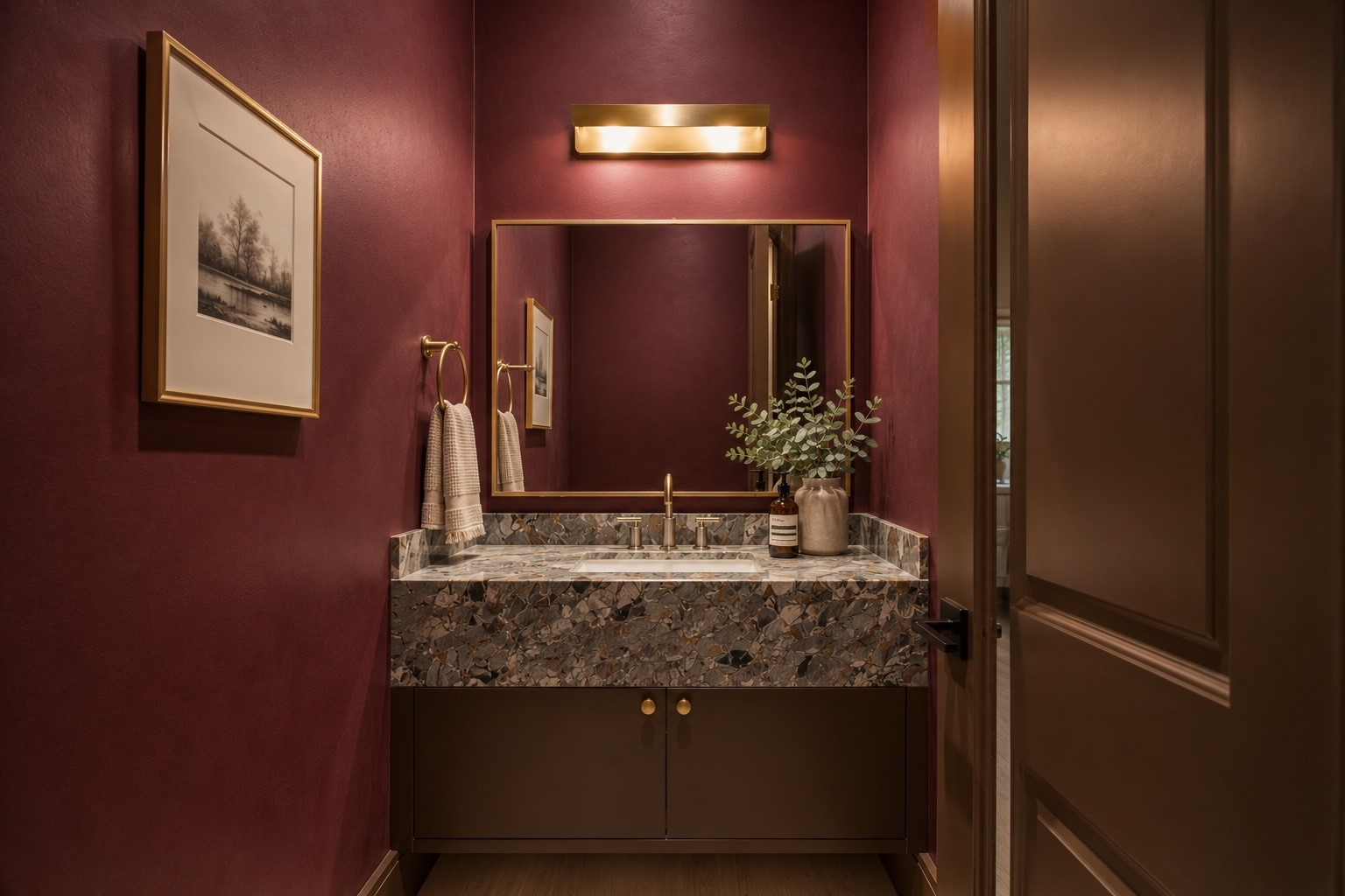 Rich lime washed walls create a dramatic backdrop for this designer powder bath, complemented by a floating vanity with a unique red quartzite countertop, an integrated sink, and warm brass fixtures. A bold, elevated space that leaves a lasting impression for guests.
