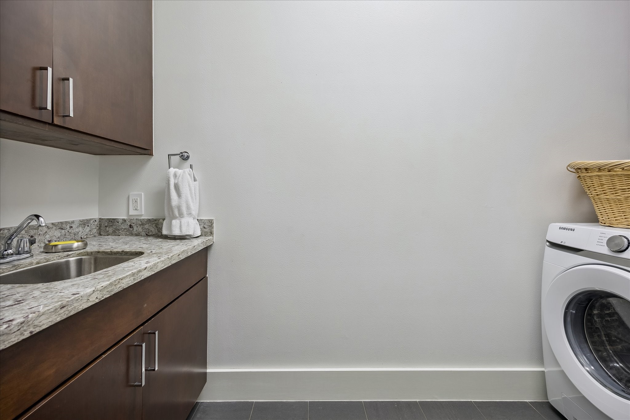 LAUNDRY ROOM with storage cabinets and sink.