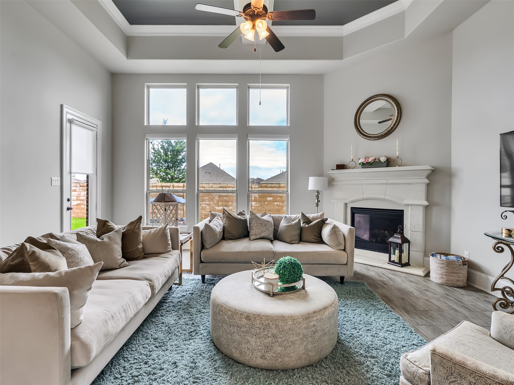 This spacious family room features coffered ceilings, crown molding, and large windows.