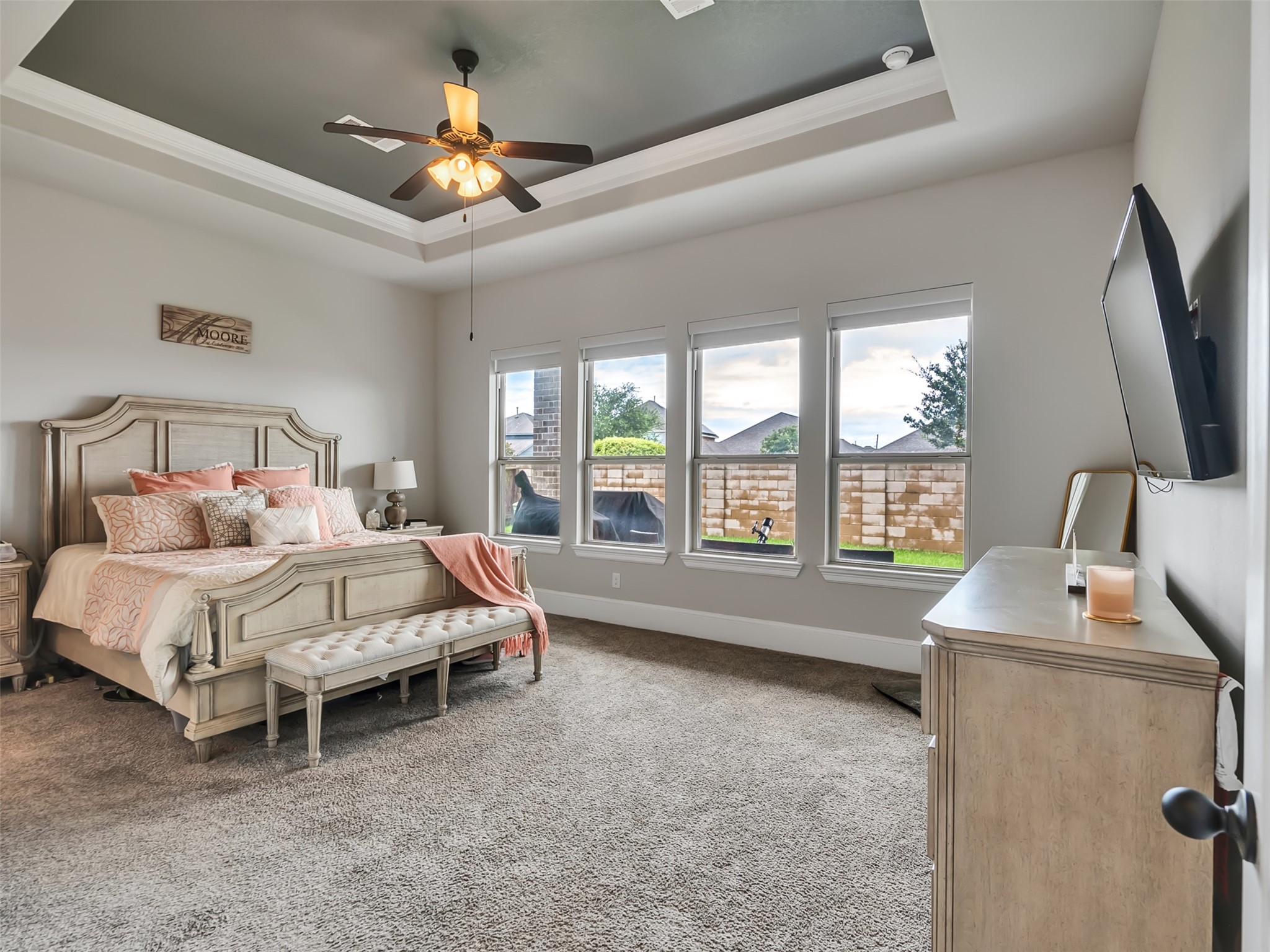 Welcome to the Primary bedroom suite where natural lighting and tray ceilings offer a comfortable and stylish ambiance.